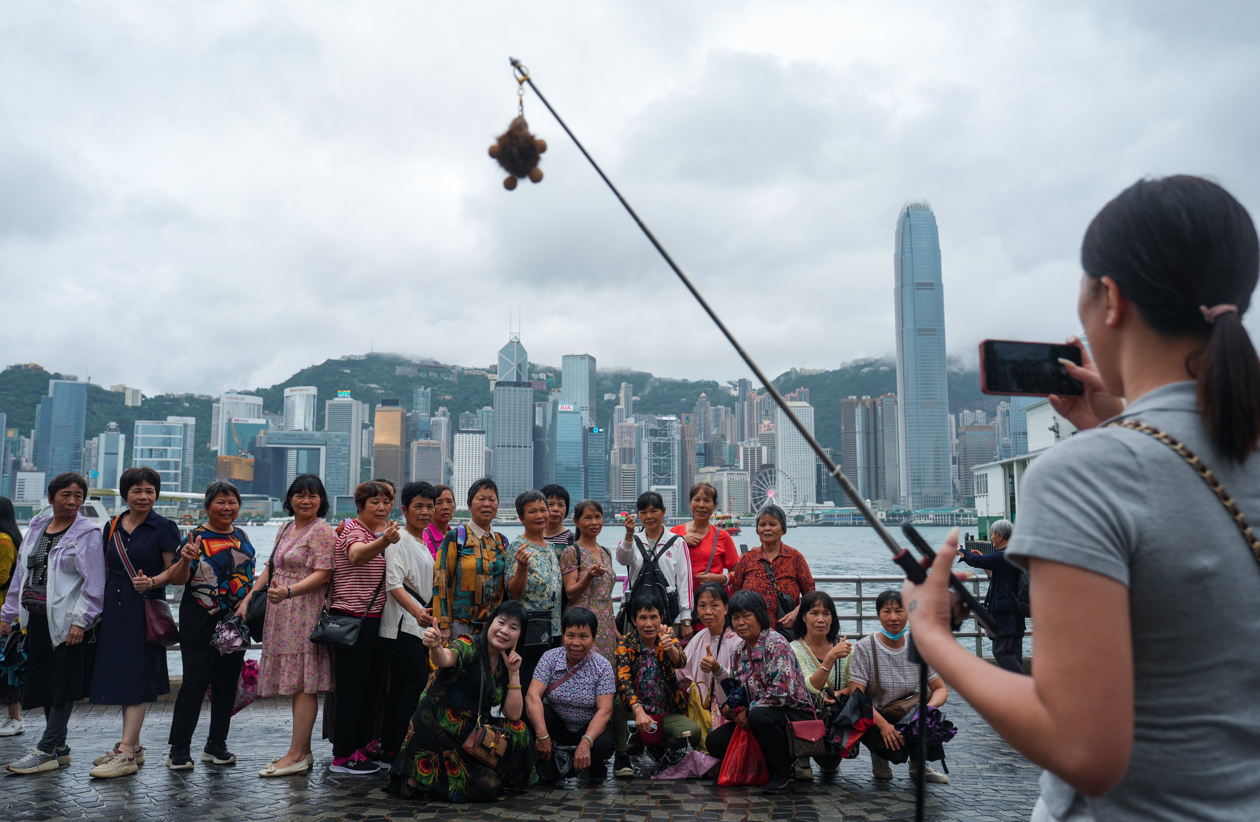 Visitors pose for a photo in Tsim Sha Tsui. Authorities have said there may be last-minute changes to a Victoria Harbour fireworks display on May 1. Photo: Sam Tsang