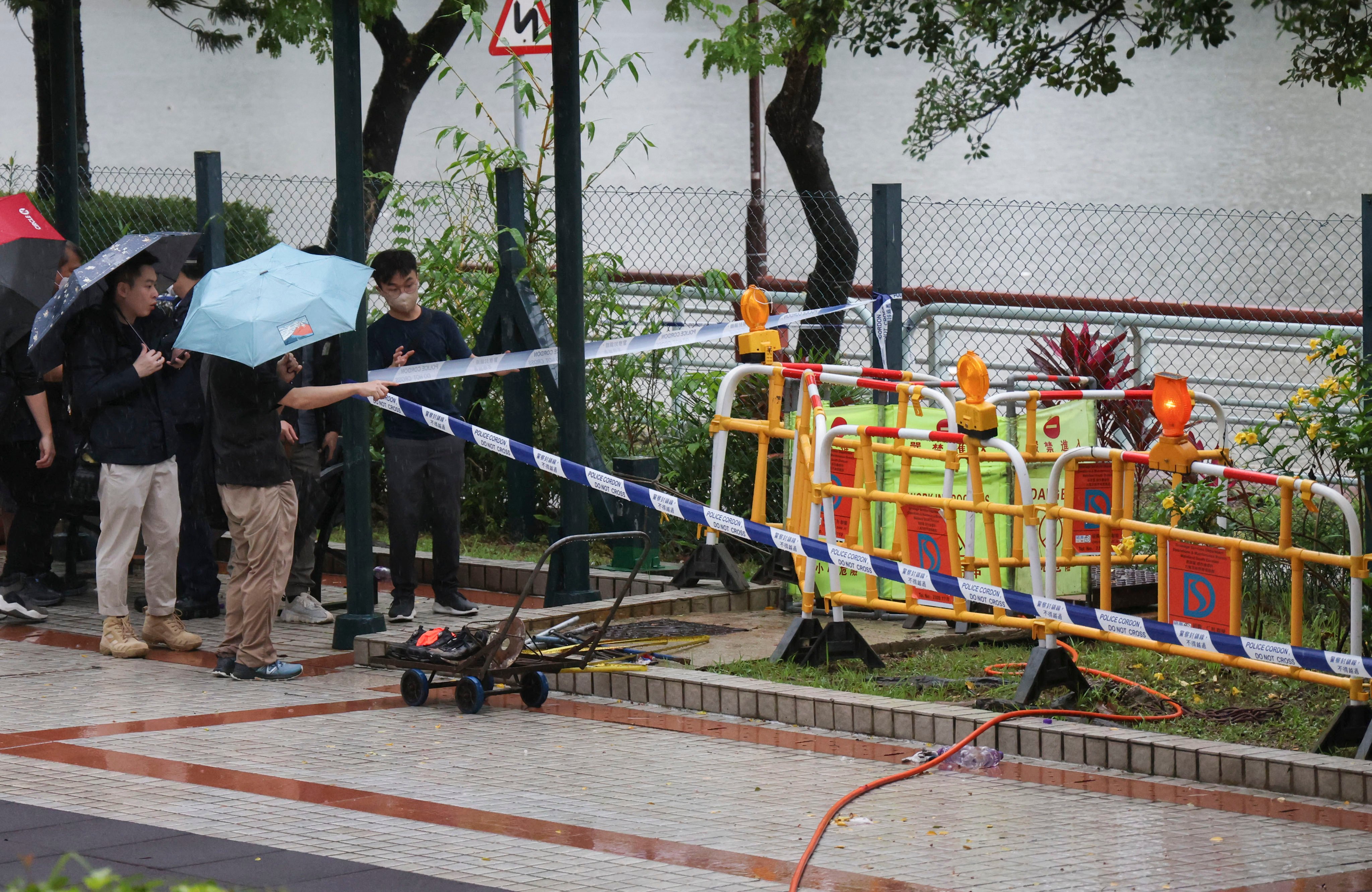 Police officers investigate the case of two  workers who were believed to have inhaled toxic gas in a manhole. Photo: Jelly Tse