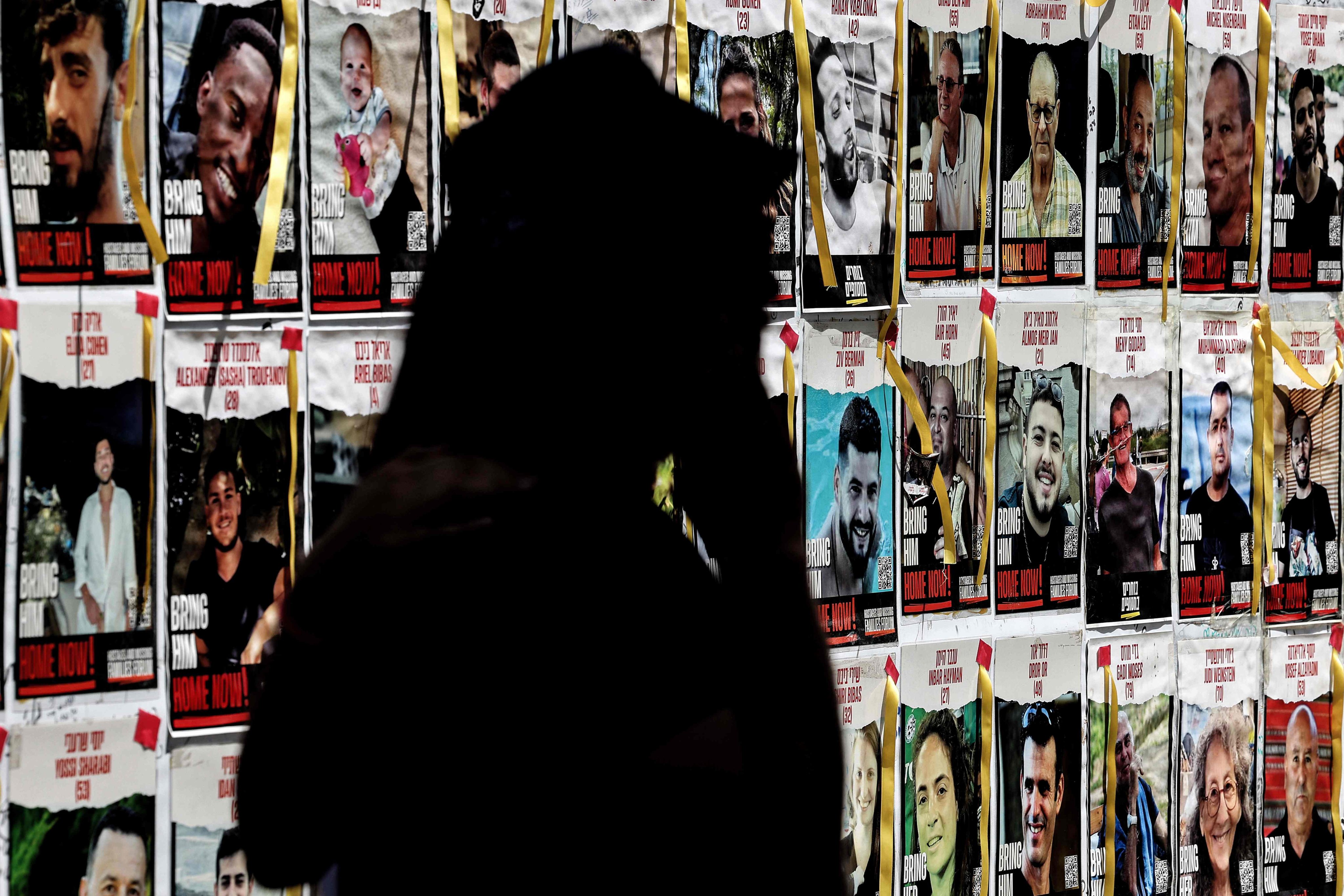 A demonstrator walks past posters of Israeli hostages held in Gaza during a protest outside Israeli defence ministry headquarters in Tel Aviv on Thursday. Photo: AFP