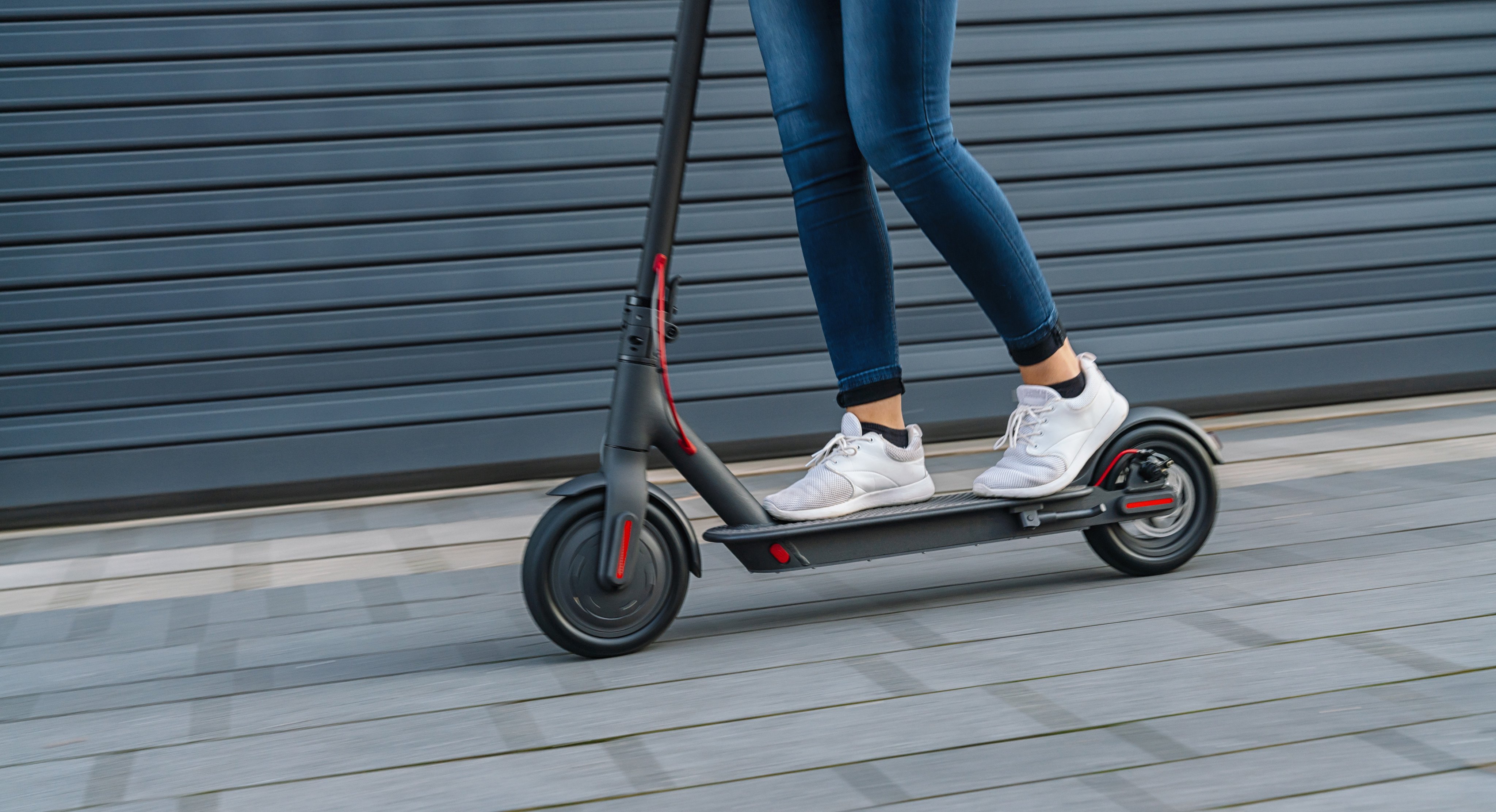 Close up of a woman riding an electric scooter. Photo: Shutterstock