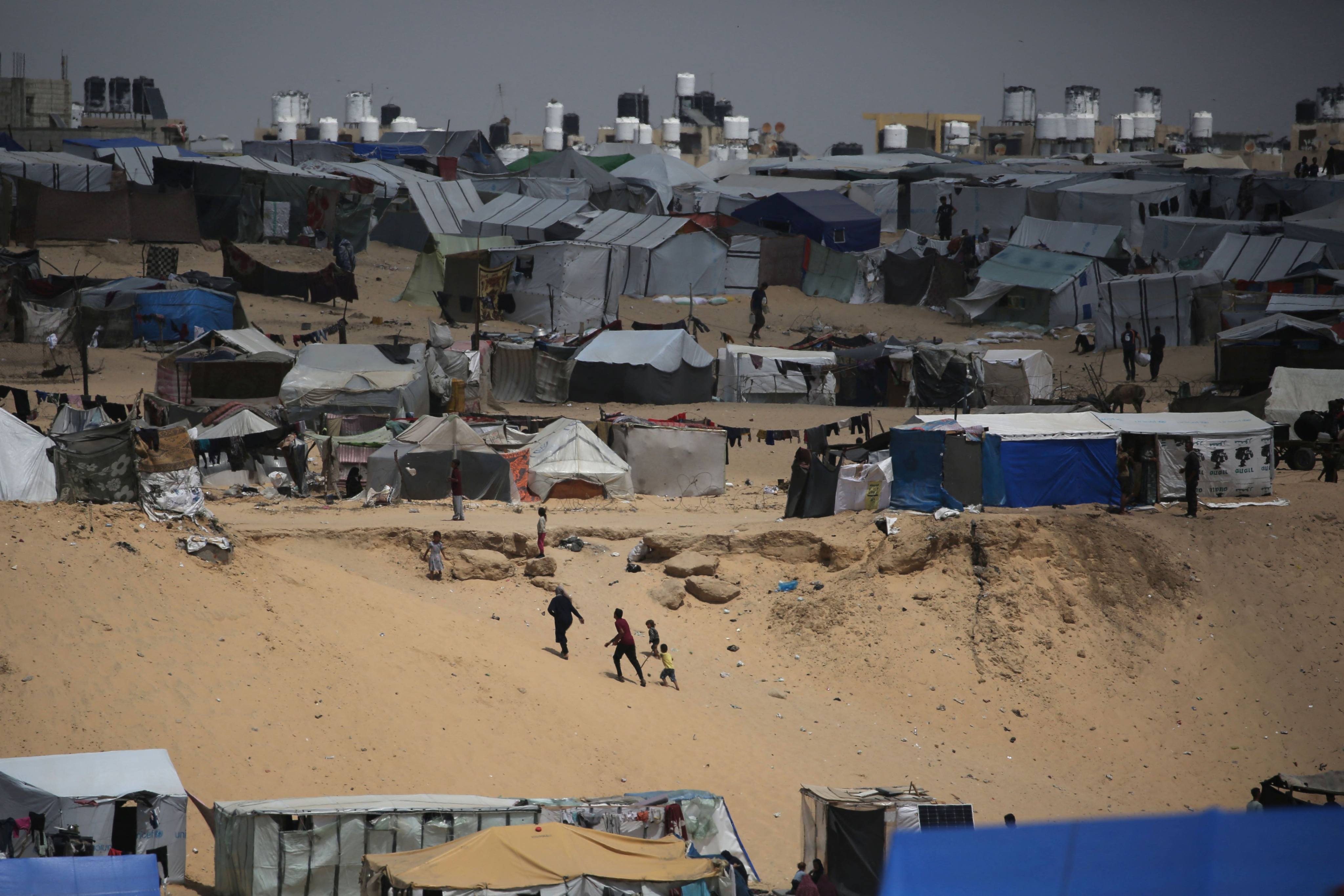 Palestinians walk in a camp for displaced people in Rafah, southern Gaza, by the border with Egypt on Sunday. Photo: AFP