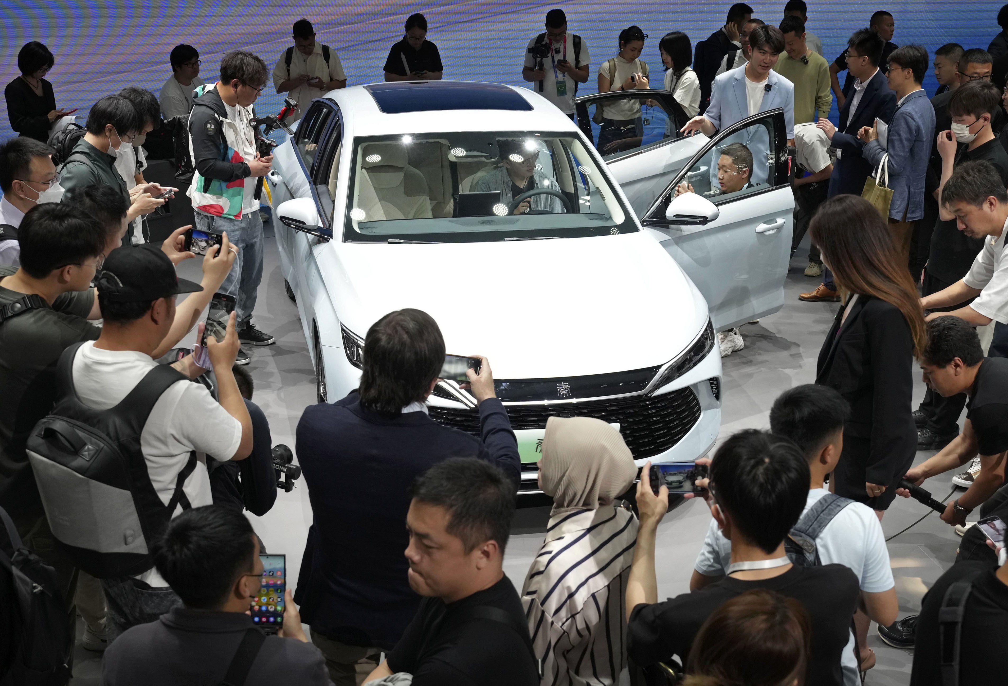 Visitors take a closer look at BYD’s new plug-in hybrid model at the Beijing International Automotive Exhibition on April 25. Photo: Kyodo