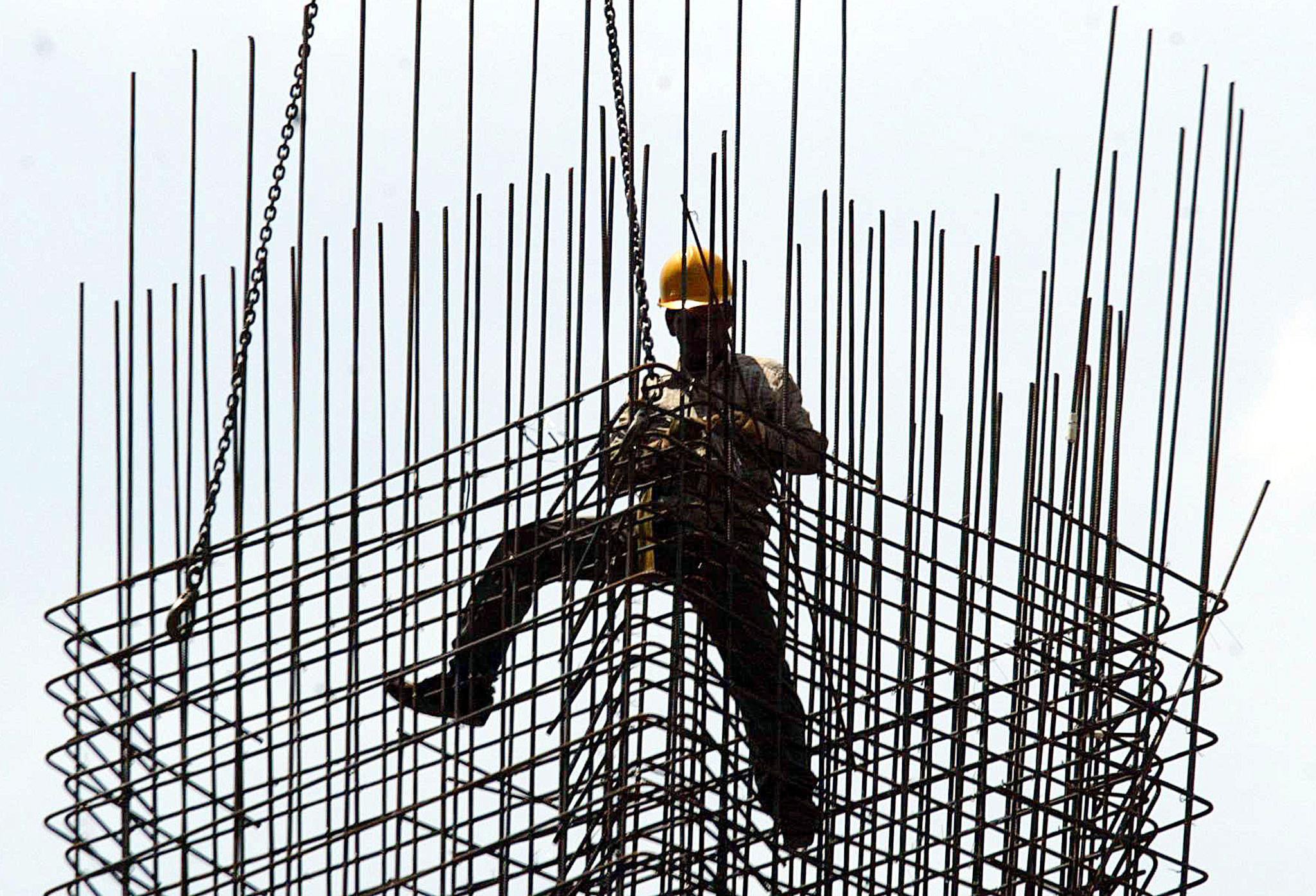 A worker secures a metal frame at a construction site in Singapore. The dip was largely driven by a slump in construction jobs. Photo: AFP