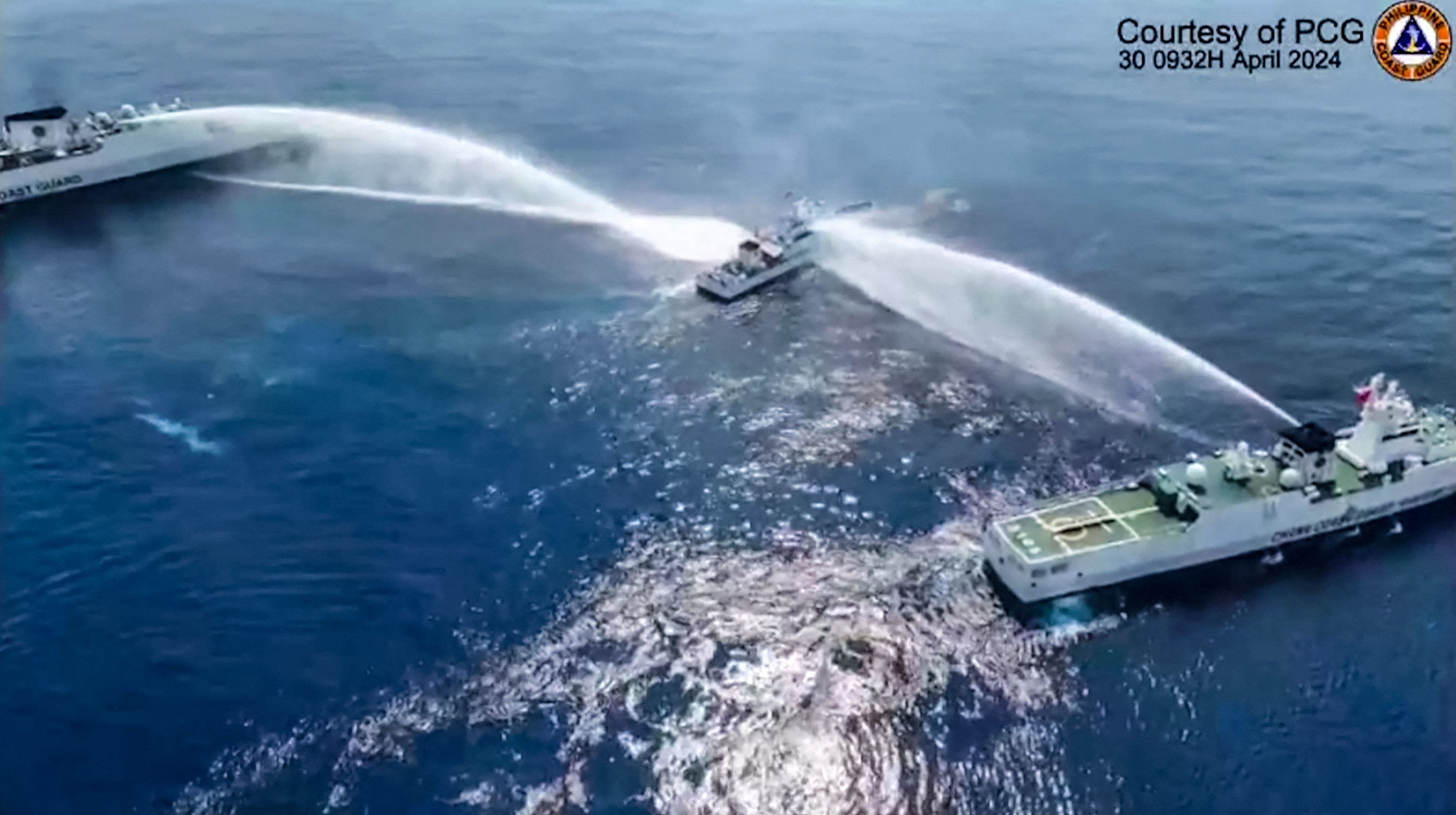 A Philippine vessel is sprayed with water cannons by Chinese coastguard ships on Tuesday as it tries to approach Scarborough Shoal in this still from a video provided by the Philippine coastguard. Photo: Philippine Coast Guard/Handout via AFP