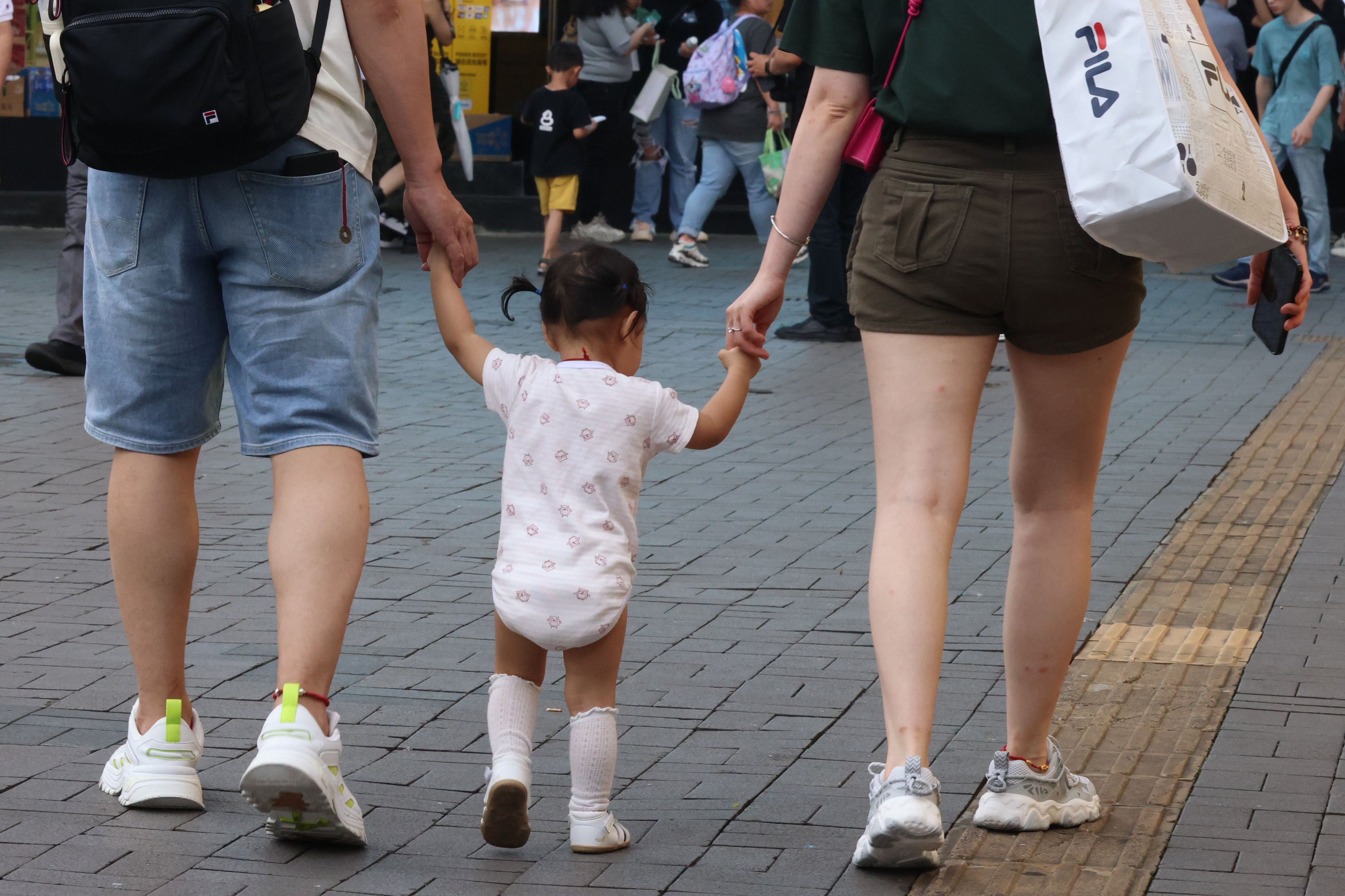 Two parents with their child pass by the Tsim Sha Tsui waterfront. The recent deaths of three girls underscore the importance of people getting inoculated against flu. Photo: Jelly Tse