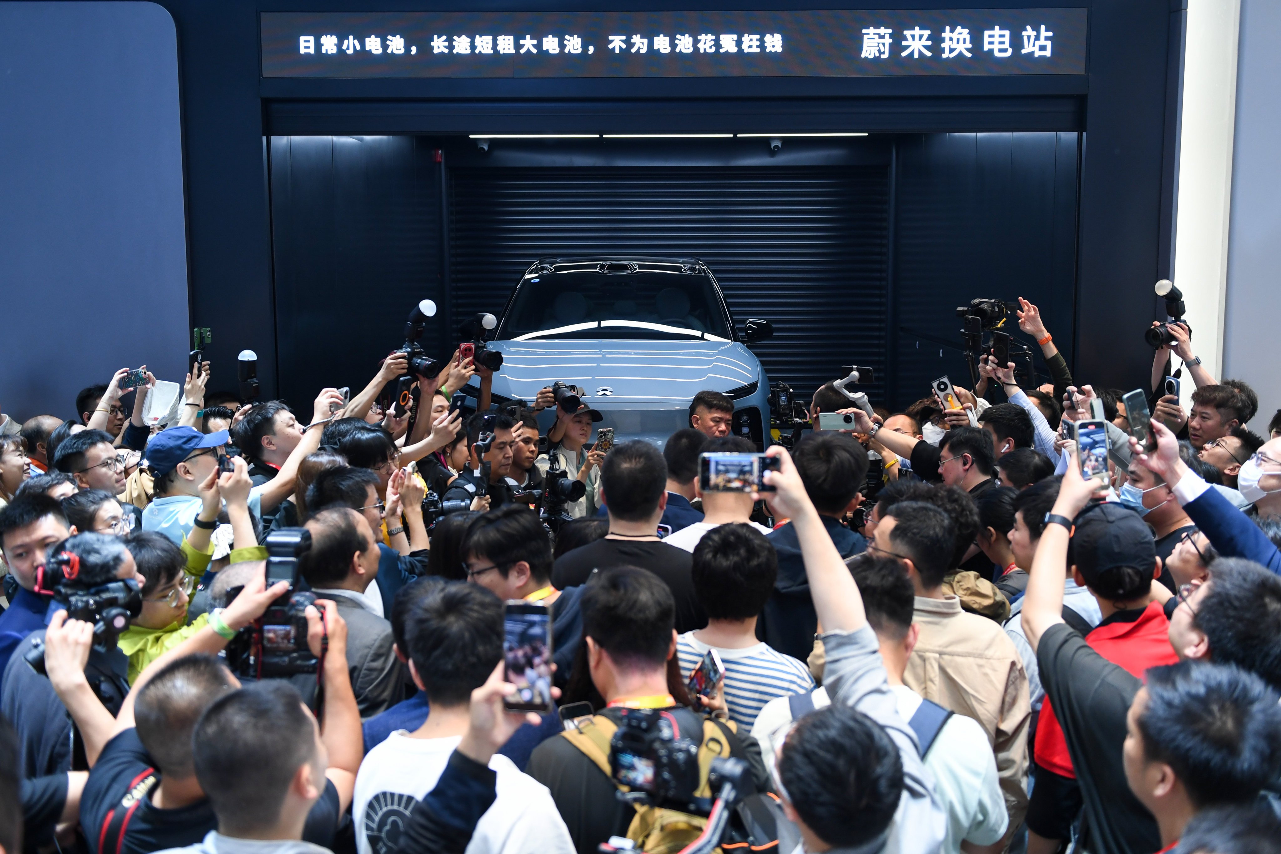 Visitors watch a demonstration at Nio’s battery swap station at the Beijing International Automotive Exhibition in April. Photo: Xinhua