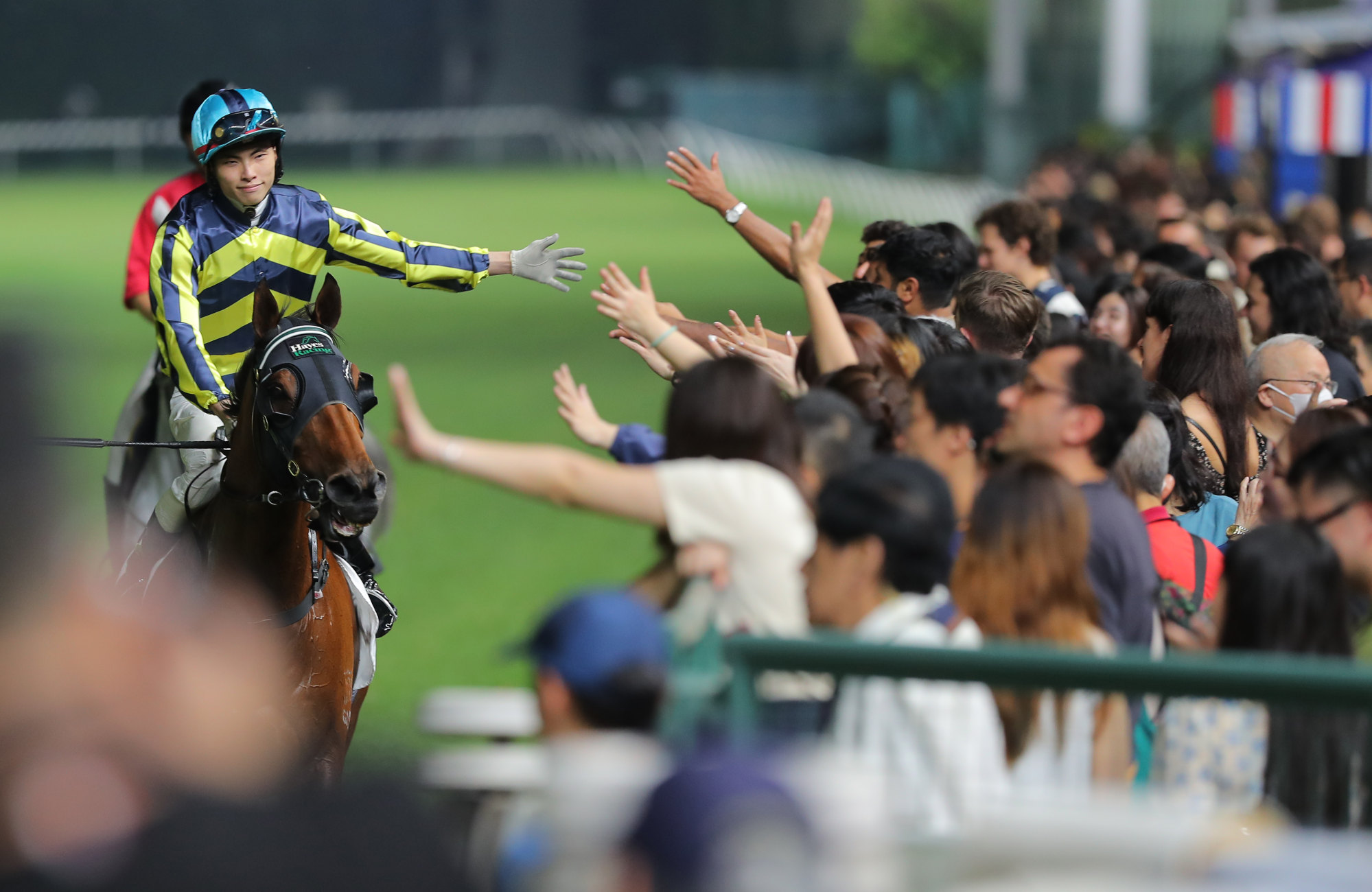 Ellis Wong high-fives the Happy Valley crowd after winning on Dragon Delight.