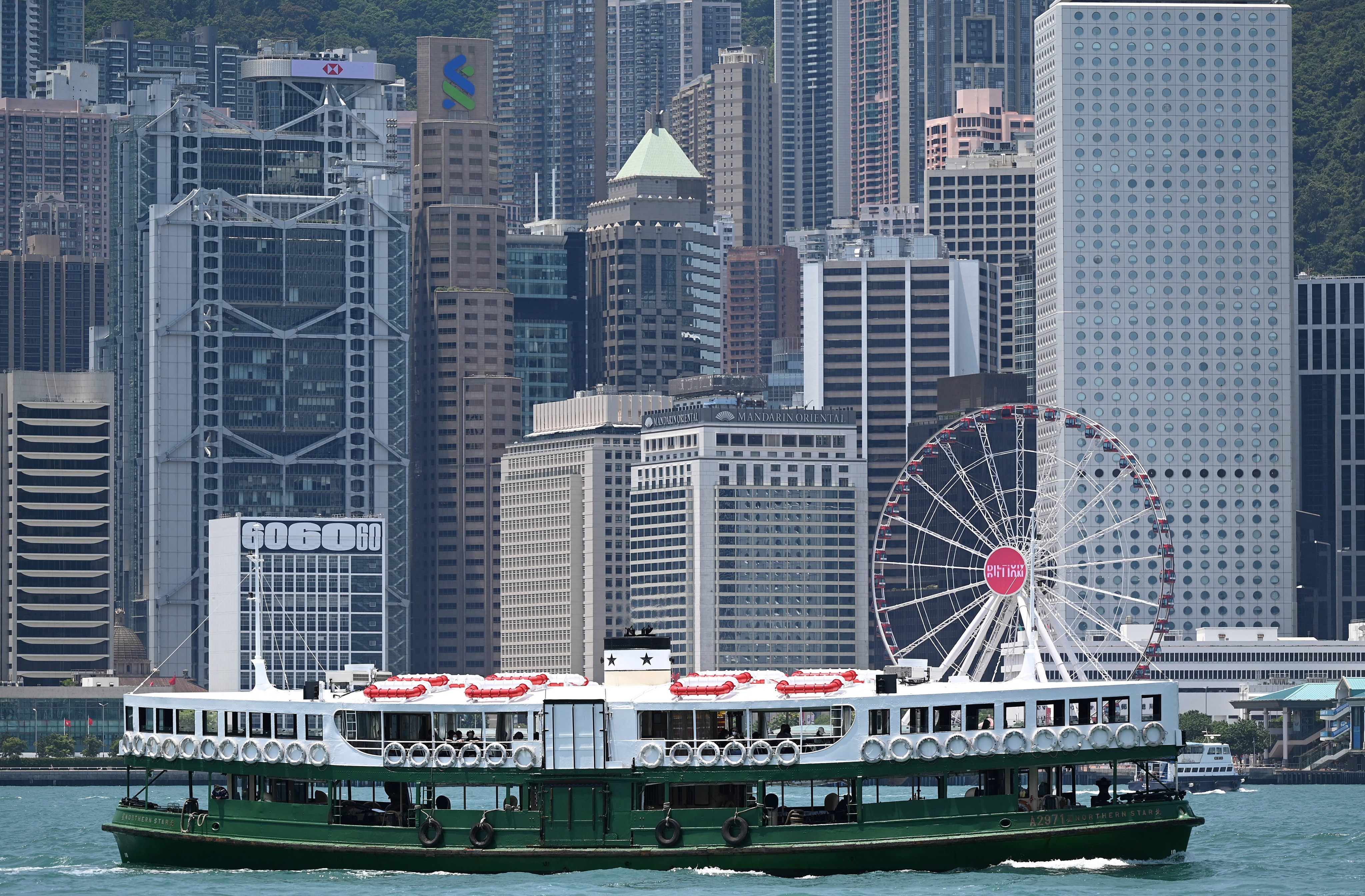A Star Ferry crosses Victoria Harbour in Hong Kong to the backdrop of buildings housing banks and financial institutions on May 4, 2022. Photo: AFP
