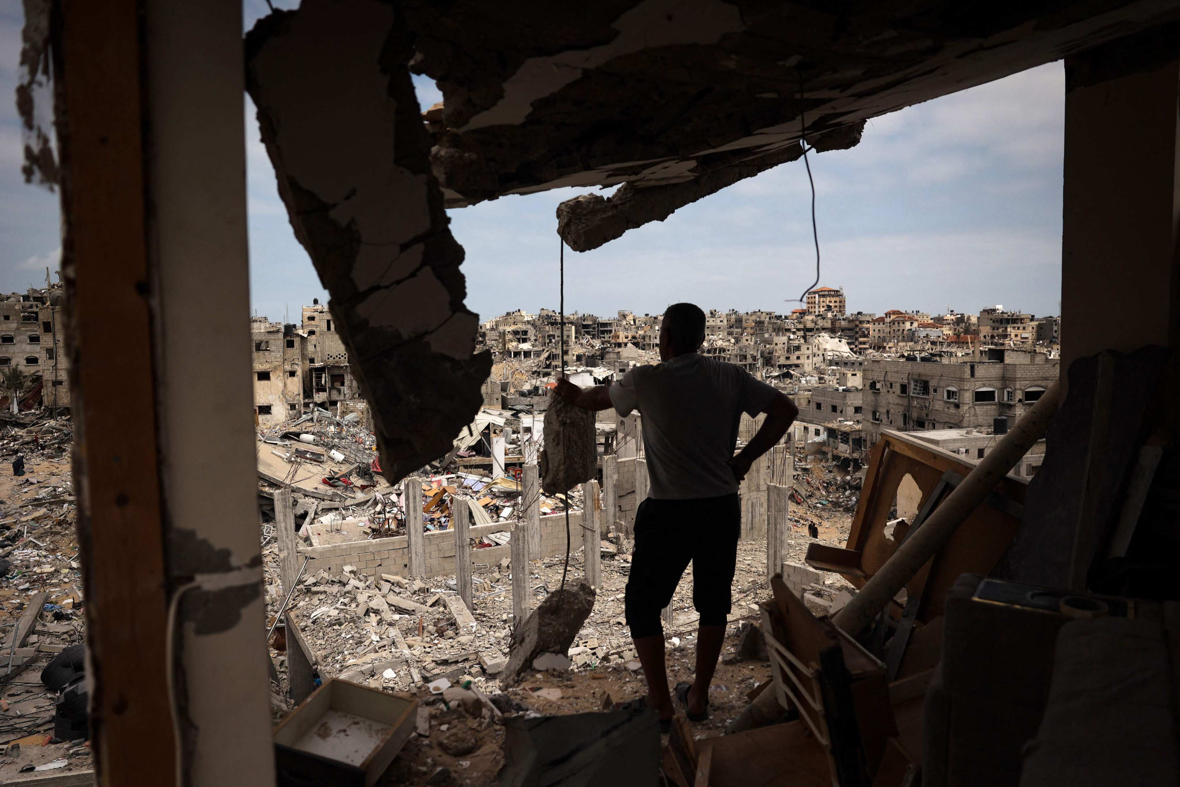 A Palestinian man looks at a ravaged neighbourhood from a destroyed flat in Khan Younis in the southern Gaza Strip. Photo: AFP
