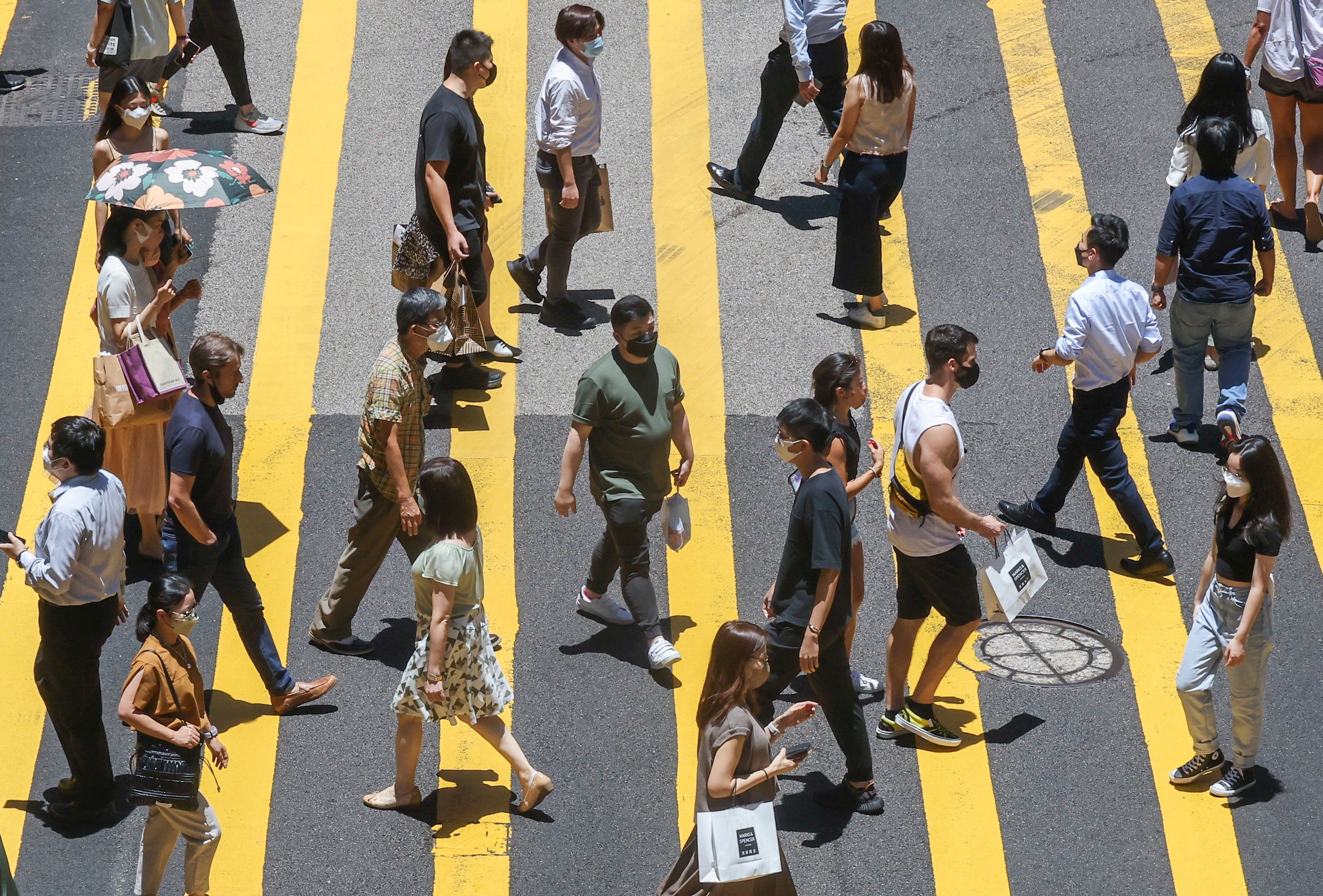 Pedestrians cross a street in Central district, Hong Kong, on August 1, 2022. To thrive in the evolving landscape, the city must focus on redefining its identity to attract a diverse pool of talent. Photo: Jonathan Wong