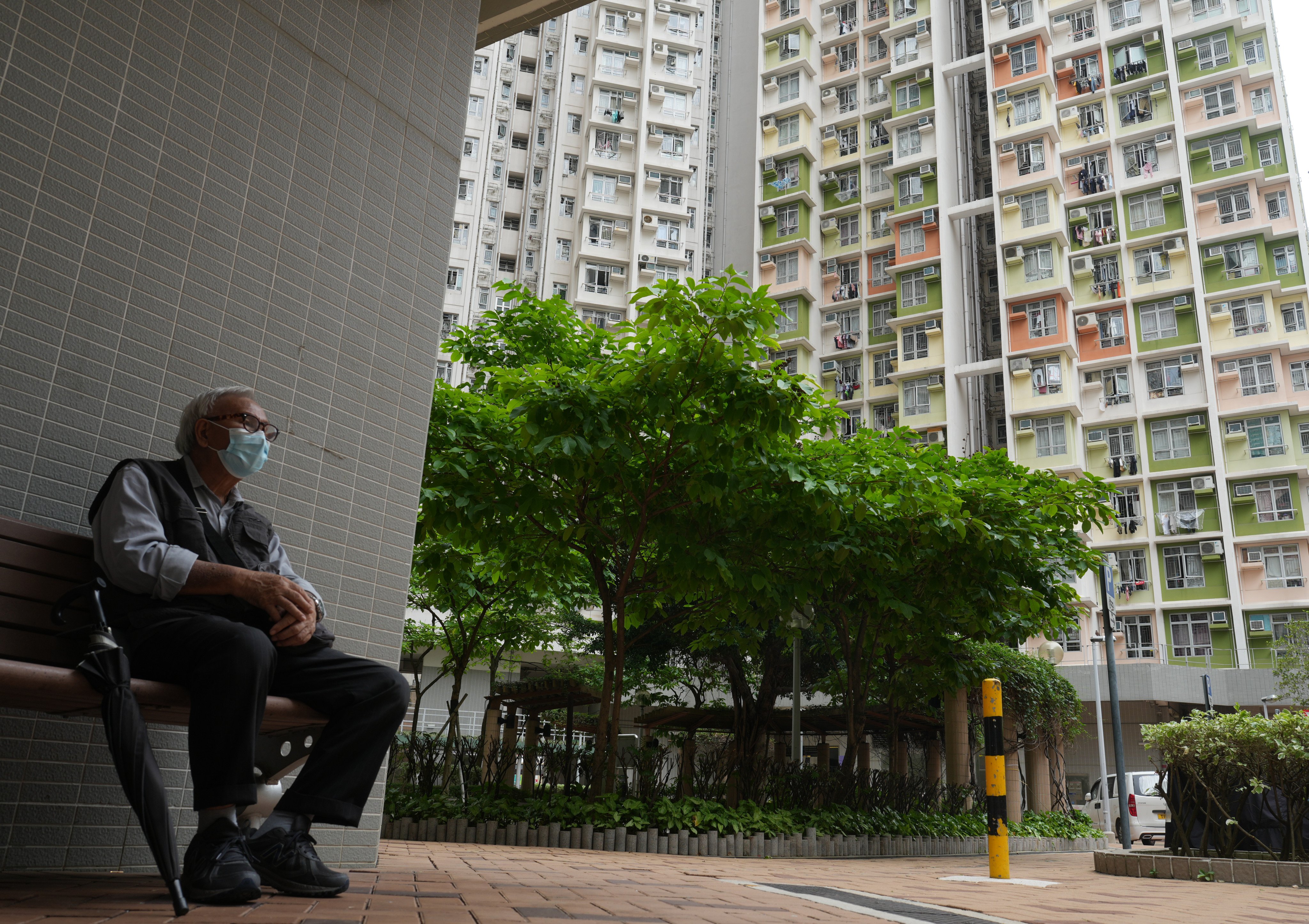 A man sits outside public housing at Cheung Sha Wan on May 11, 2023. The average waiting time for a public rental flat now stands at nearly six years. Photo: Sam Tsang