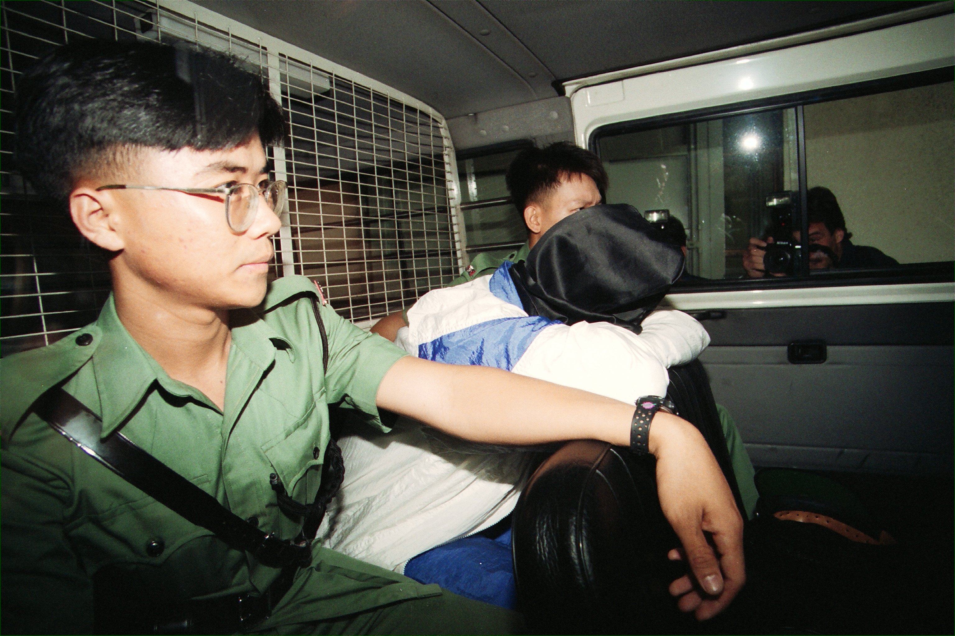 Police Sergeant Leung Chung (in hood) was charged with shooting Police Chief Inspector Leung Chi-lung at the Castle Peak divisional station, in Hong Kong, in 1994. Photo: SCMP