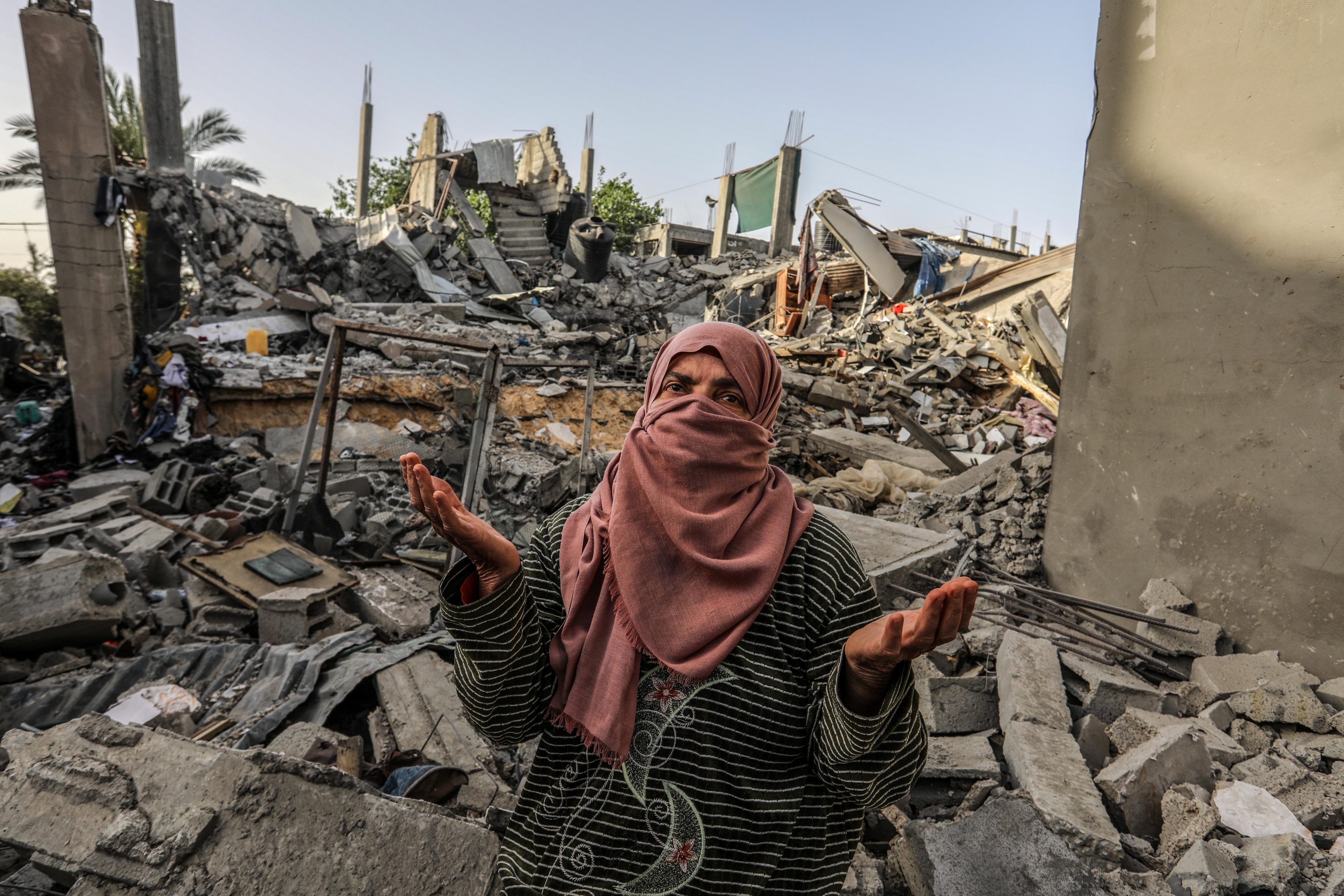 A Palestinian woman inspects a house that was destroyed in Israeli bombing, in the southern Gaza Strip last week. Photo: dpa 
