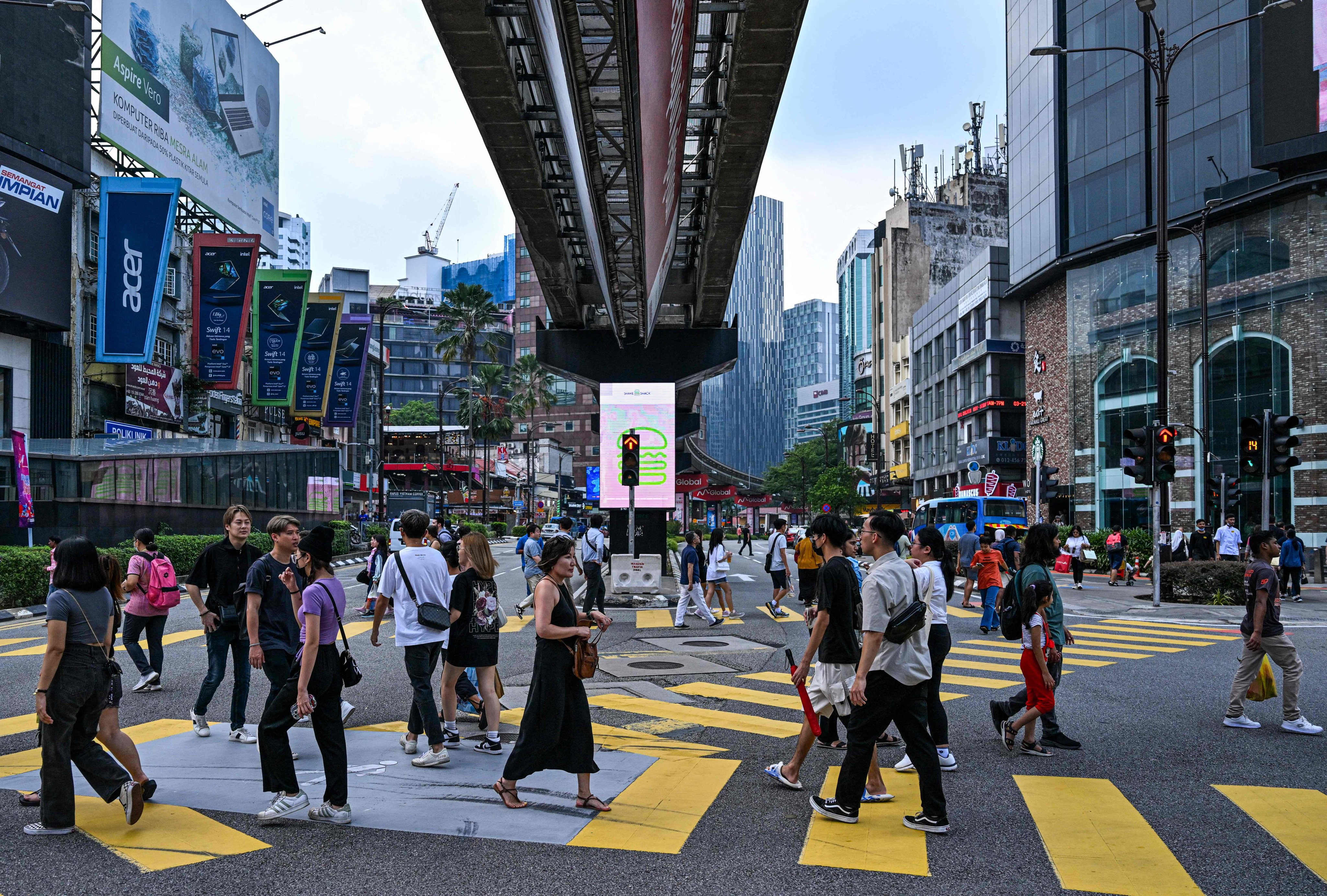 Pedestrians cross a road in Kuala Lumpur. Many Malaysians have accused the government of providing preferential treatment for the country’s civil servants. Photo: AFP