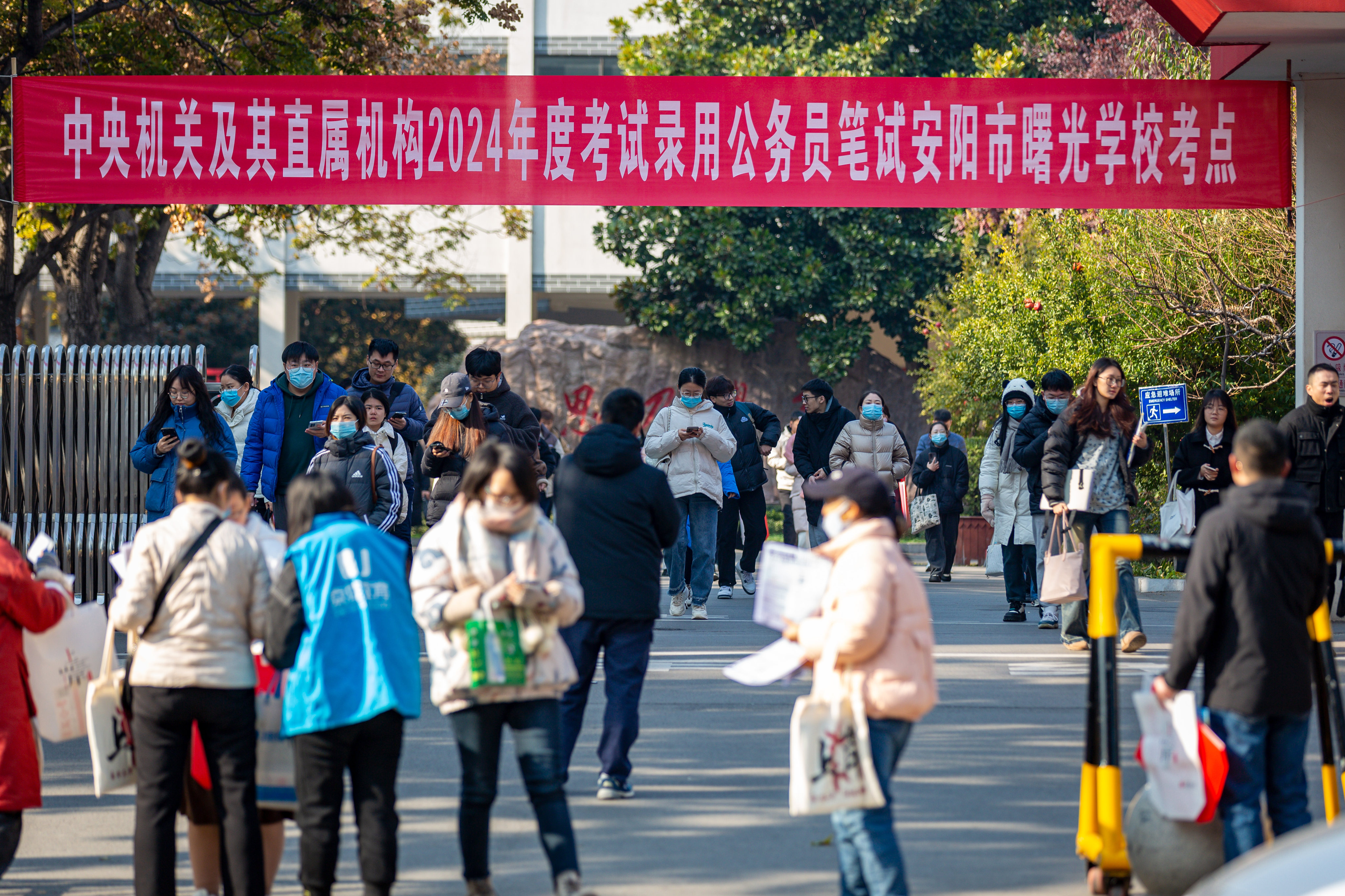 In Henan, applicants walk out of an exam venue hosting the 2024 China’s national civil servant exam. The province is cutting thousands of public institution jobs. Photo: VCG via Getty Images