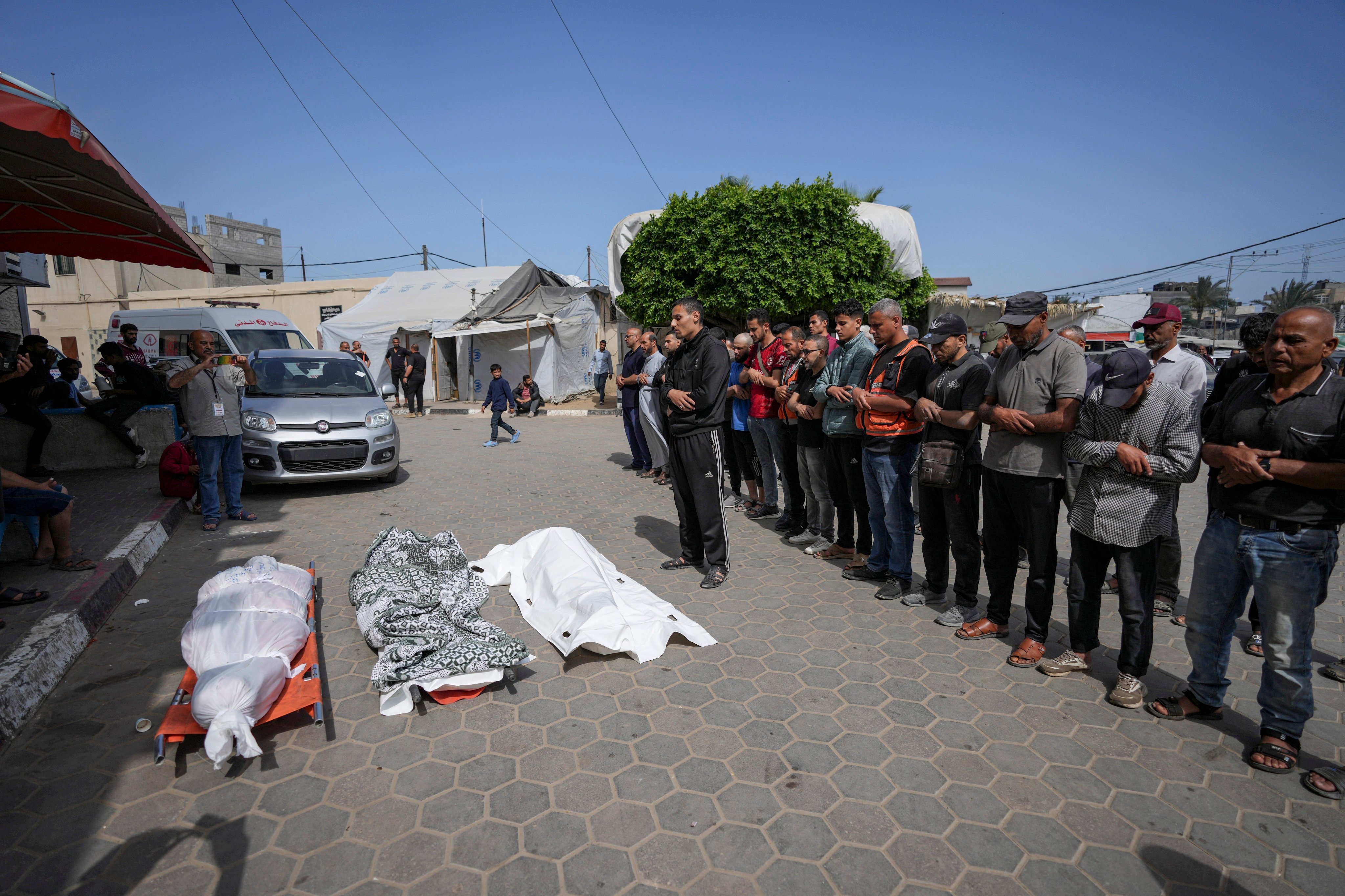Palestinians pray next to the bodies of their relatives who were killed in an Israeli airstrike in Gaza Strip, at the Al Aqsa hospital. Photo: AP