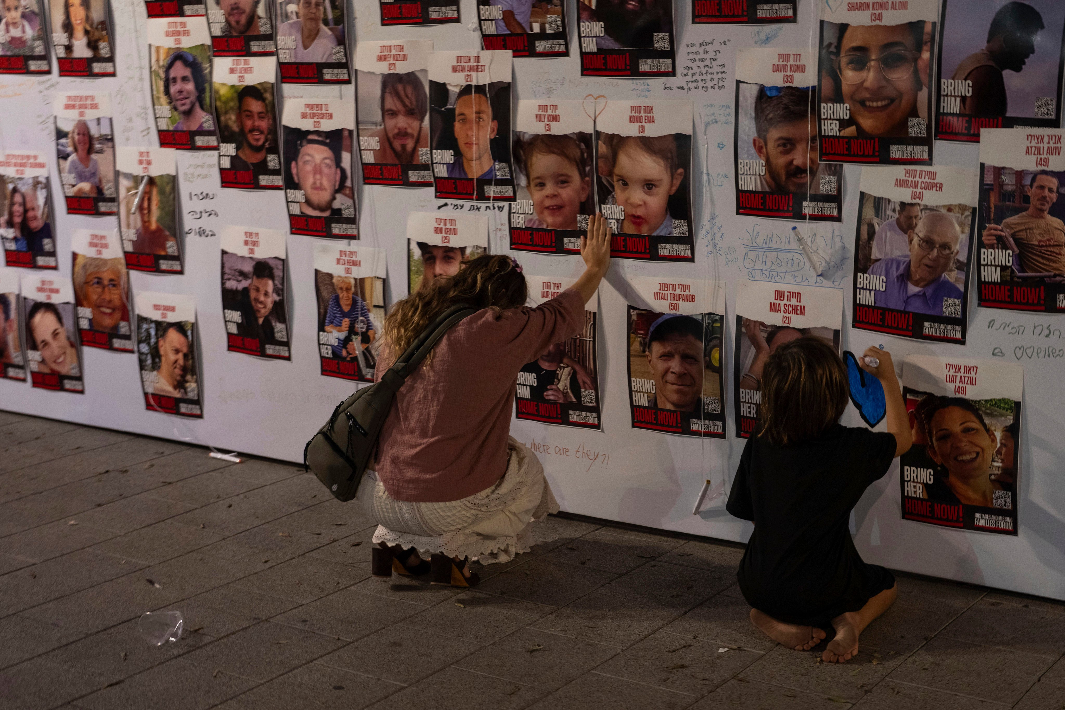 A woman in Tel Aviv touches photos of Israelis missing and held captive in Gaza after the Hamas attack in October. Photo: AP
