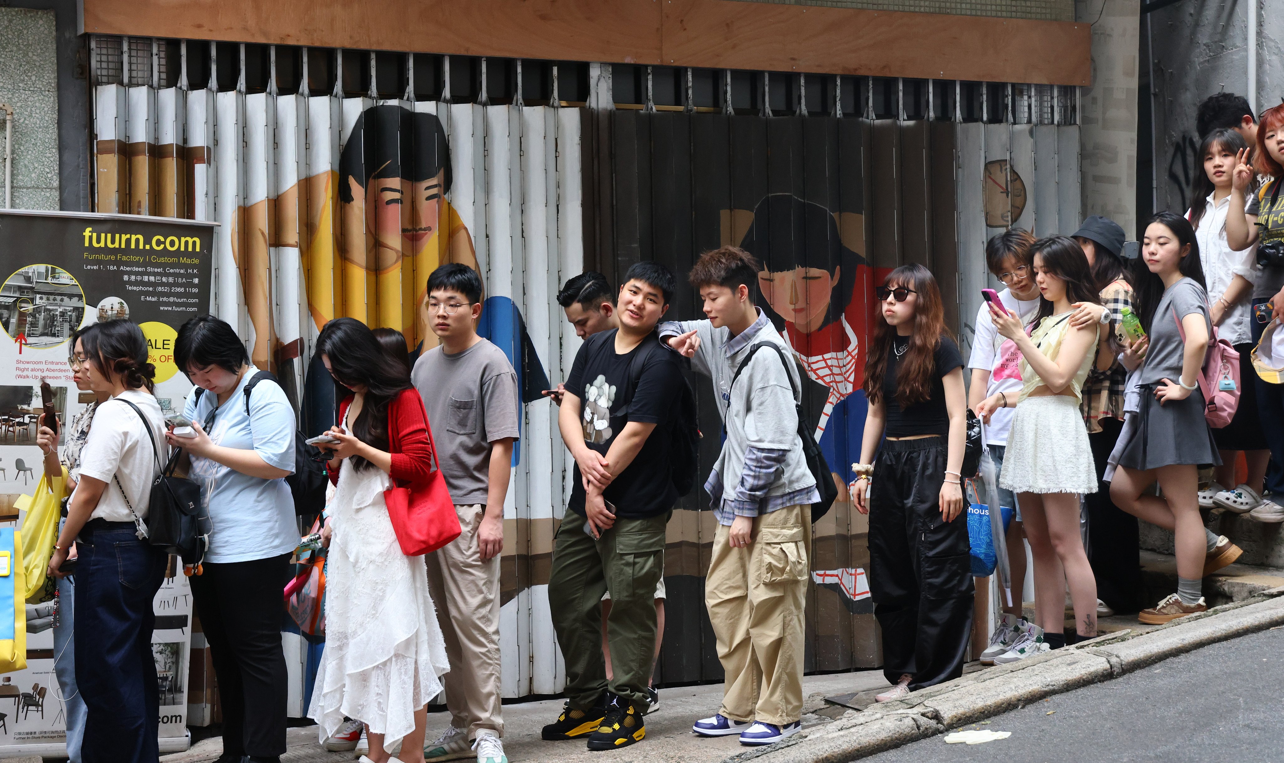 Mainland tourists queue up outside a shop in Central’s Aberdeen Street, despite a trend towards more budget trips to Hong Kong. Photo: Dickson Lee