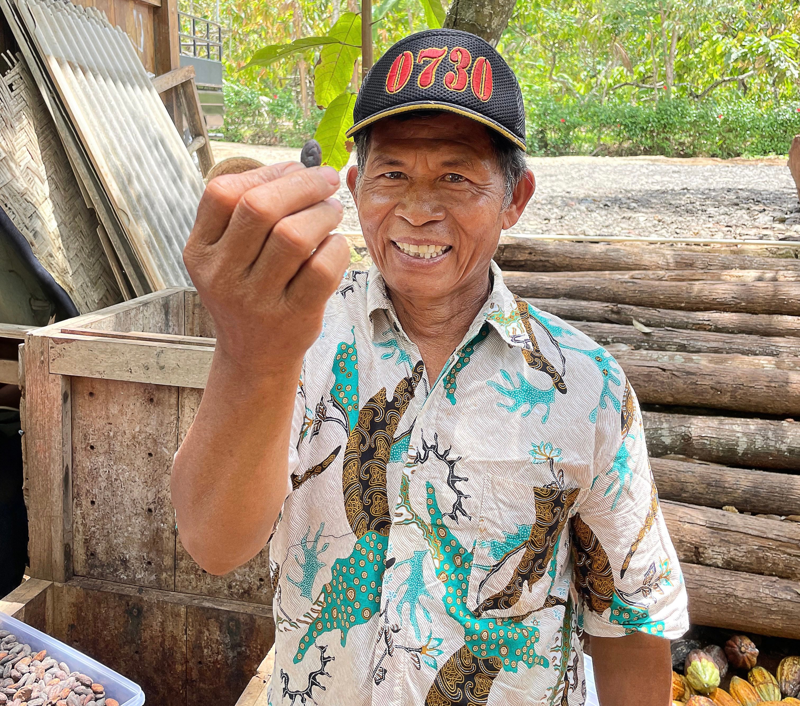 A farmer from the Indonesian village of Nglanggeran holds a cacao bean that he has harvested. Photo: Kathryn Wortley