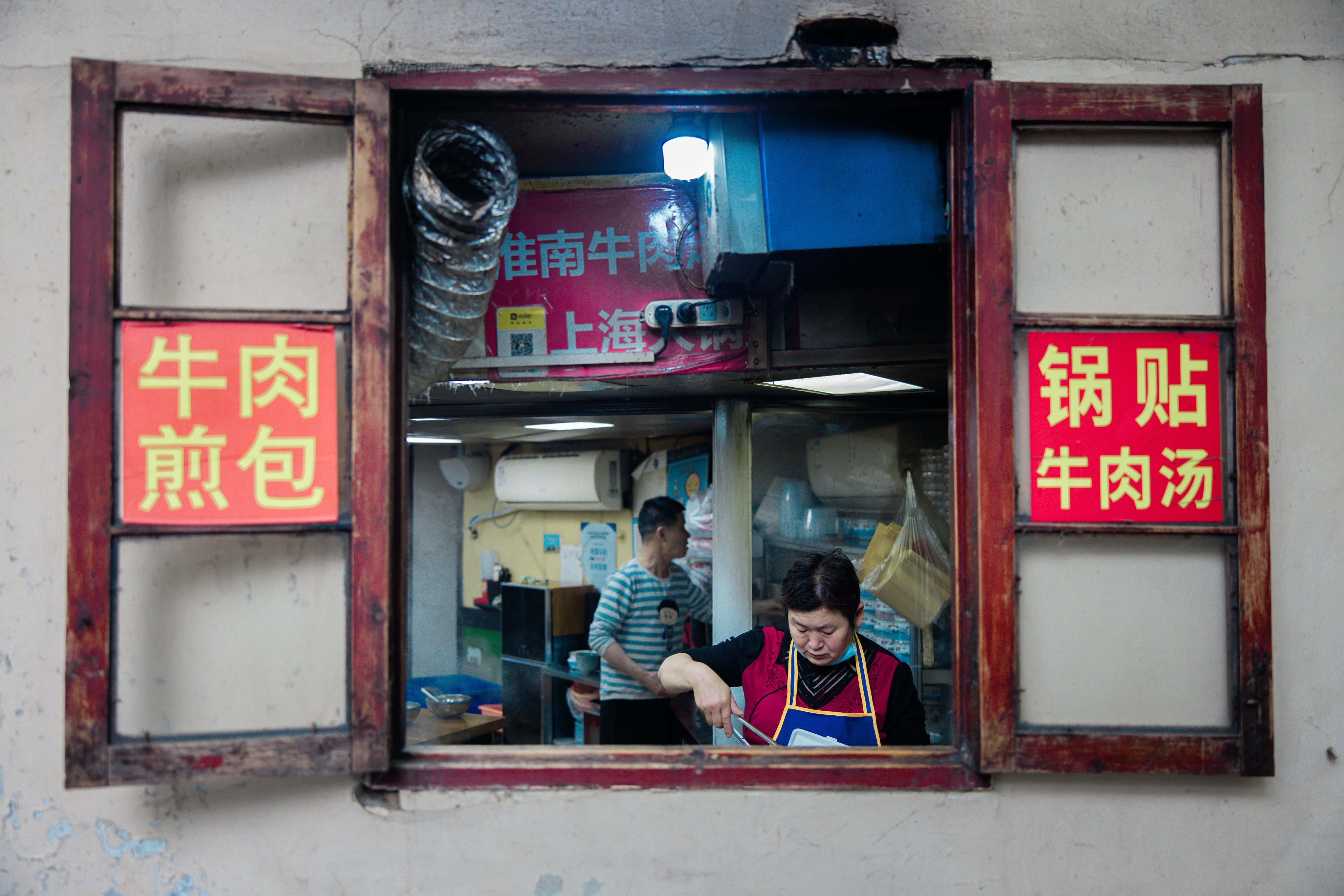 A woman cooks in a Shanghai street restaurant. Photo: EPA-EFE