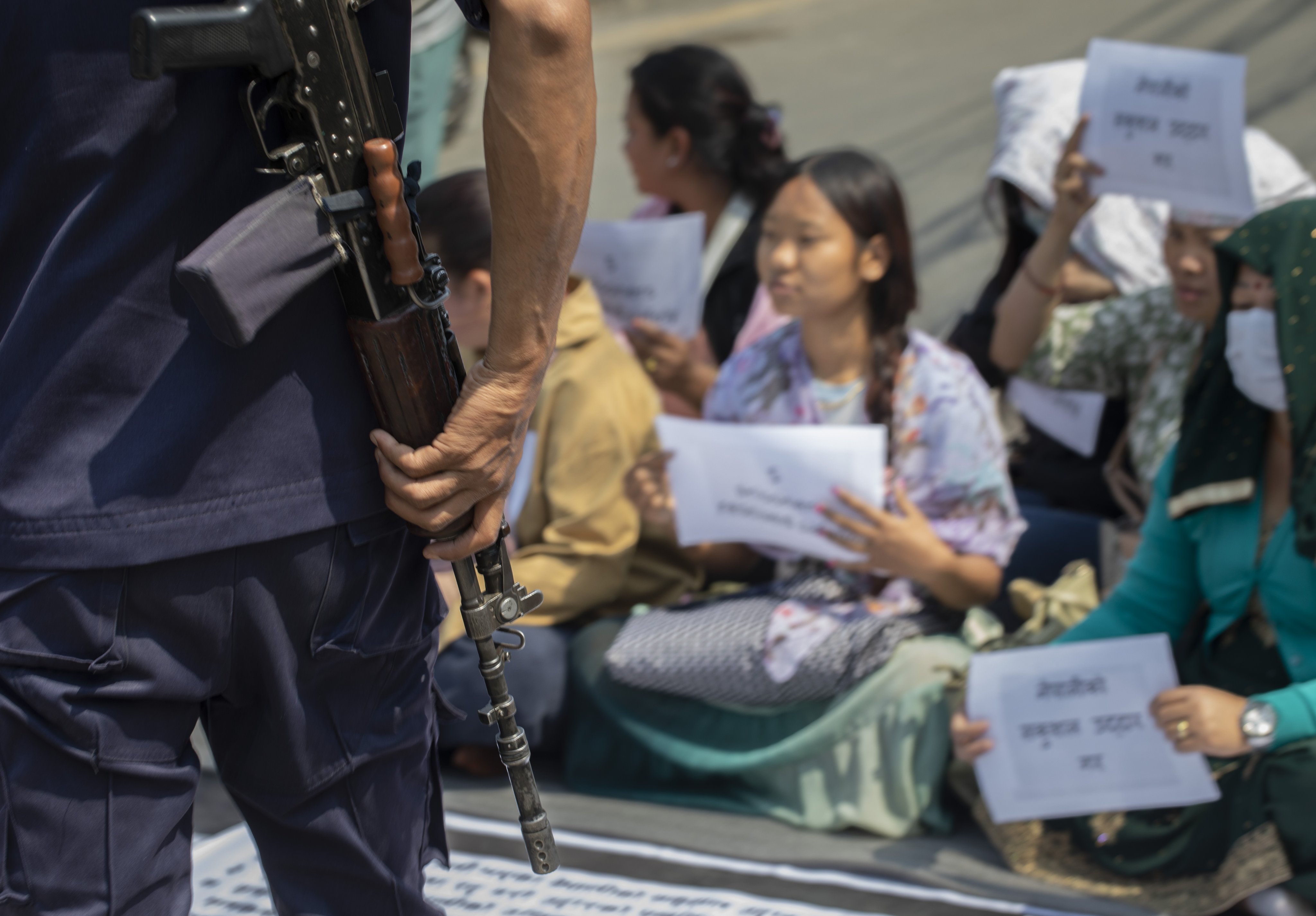 A security official looks on as family members of Nepalis who joined the Russian army stage a sit-in protest, in Kathmandu, urging their relatives’ safe return to Nepal. Photo: EPA-EFE