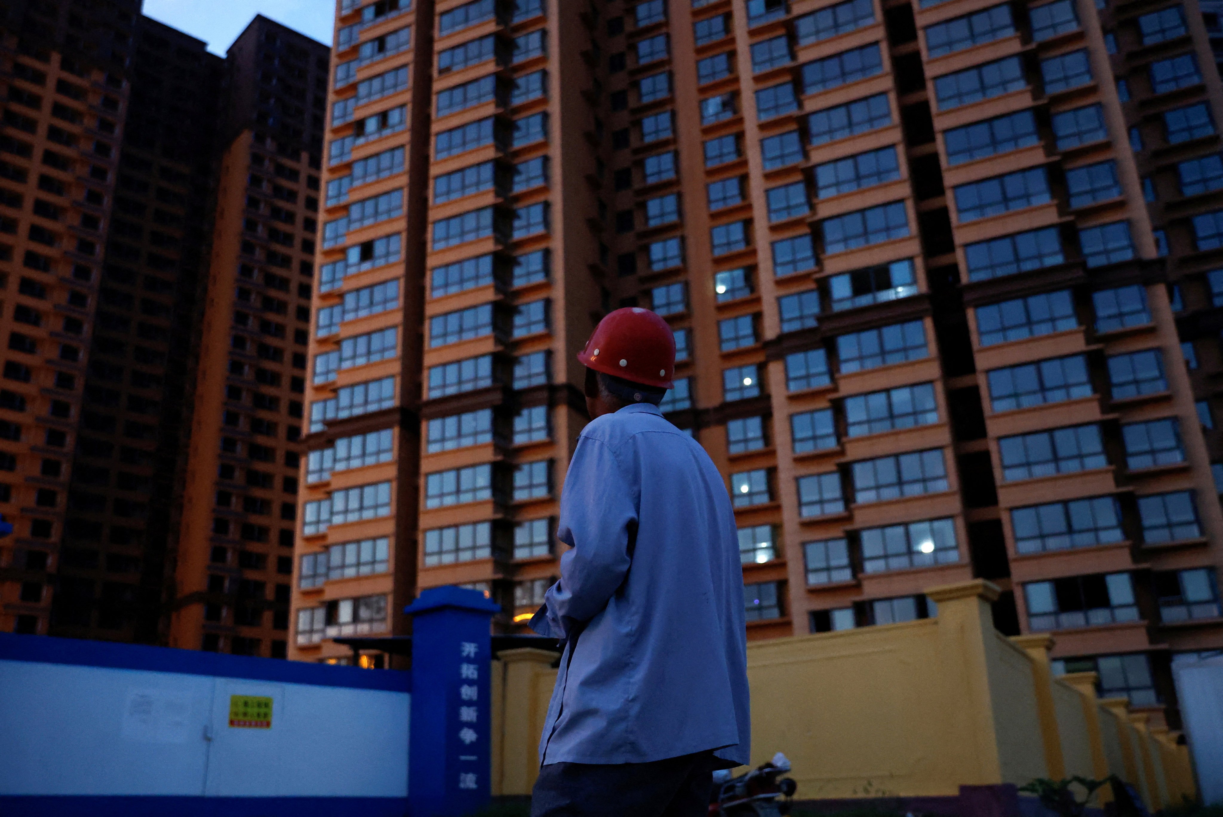 A man looks at an unfinished residential building where he bought a flat at the Gaotie Wellness City complex in Tongchuan, Shaanxi province, on September 12, 2023. Recent statements by the central government about its willingness to ‘study policies to digest the housing stockpile’ have raised hopes that the glut of unfinished but pre-sold homes will be addressed. Photo: Reuters