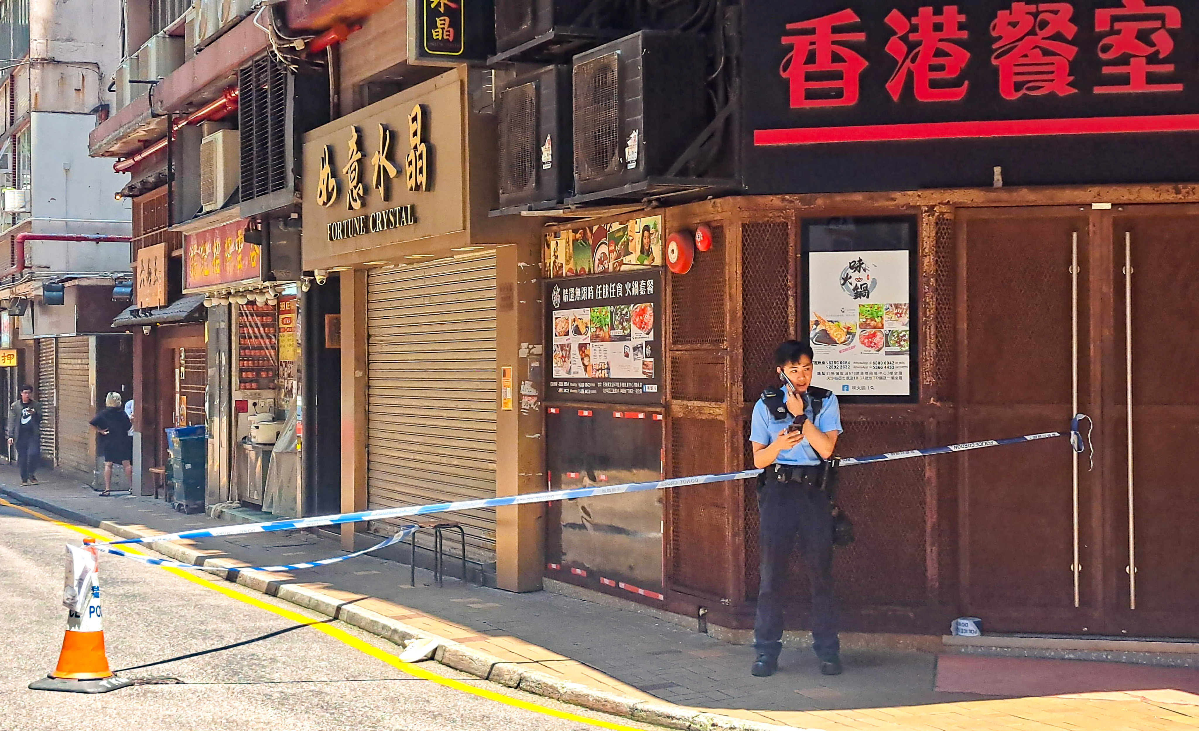 A police officer on duty at the site where a woman was bundled into a car by two men in Tsim Sha Tsui. Photo: Handout