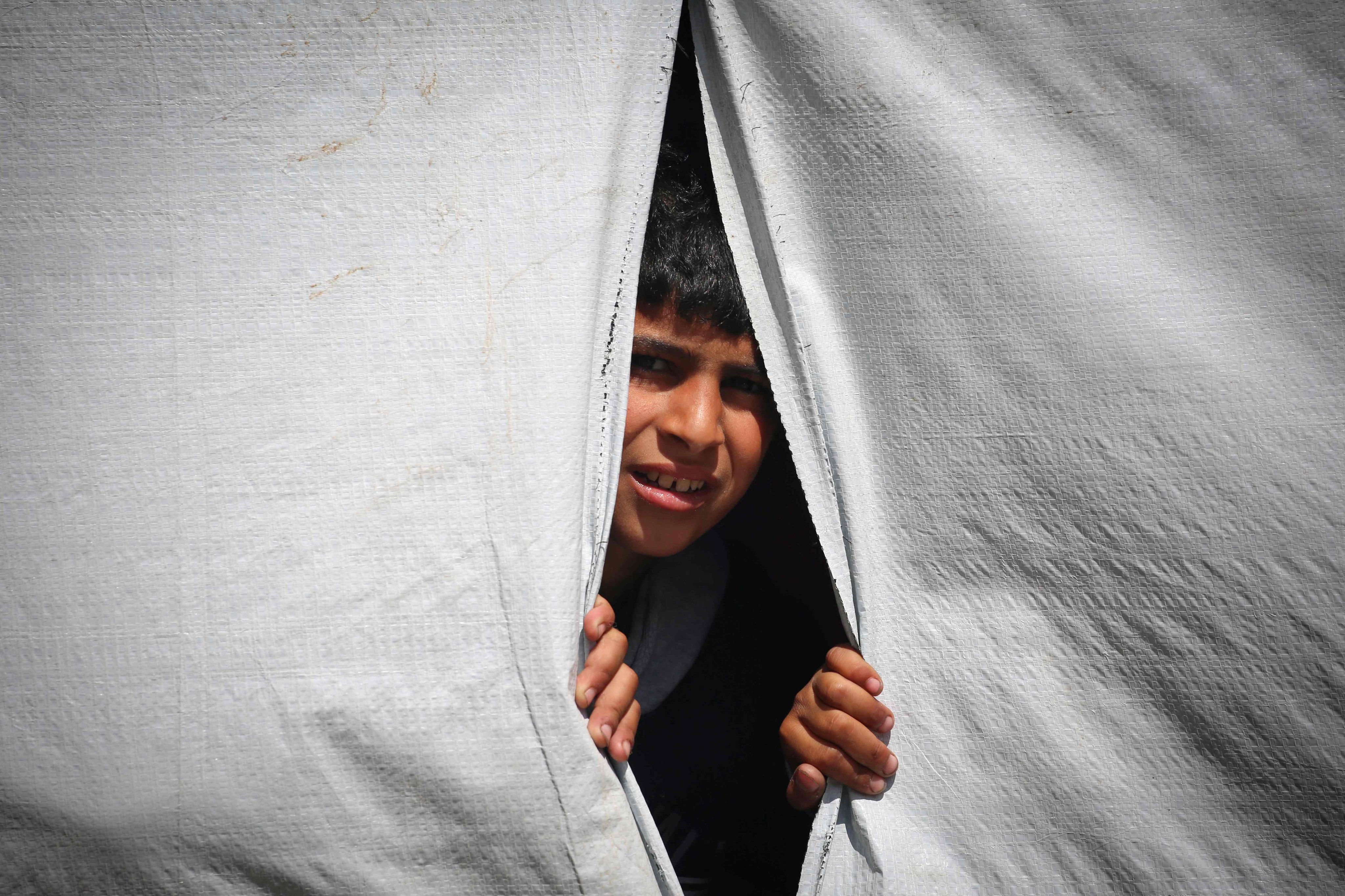 A displaced Palestinian boy looks out of a tent in Rafah in the southern Gaza Strip as people prepare to leave following an evacuation order by the Israeli army on Monday. Photo: AFP