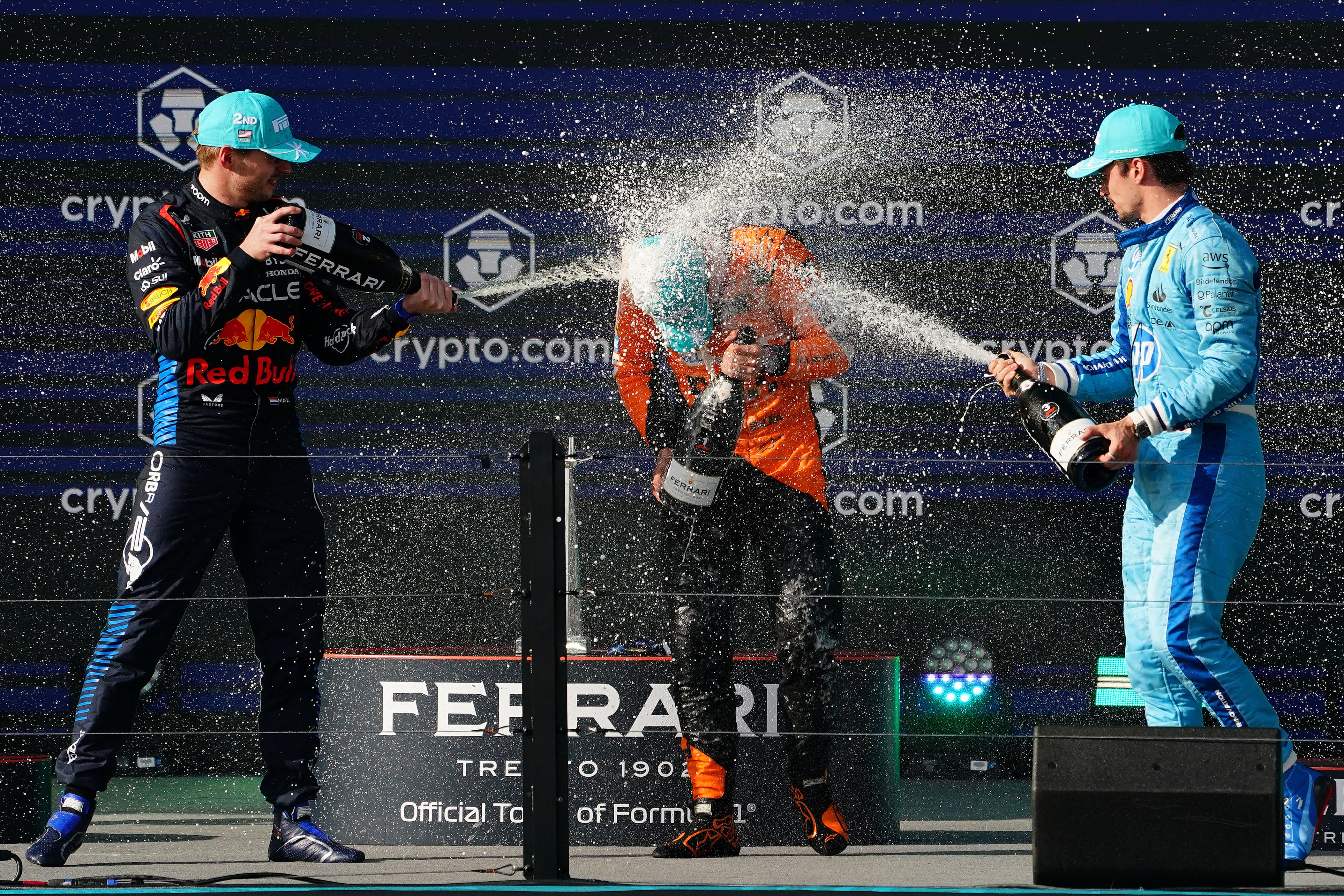 Max Verstappen (left) and Charles Leclerc (right) spray champagne on race winner Lando Norris after his maiden victory. Photo: USA TODAY Sports