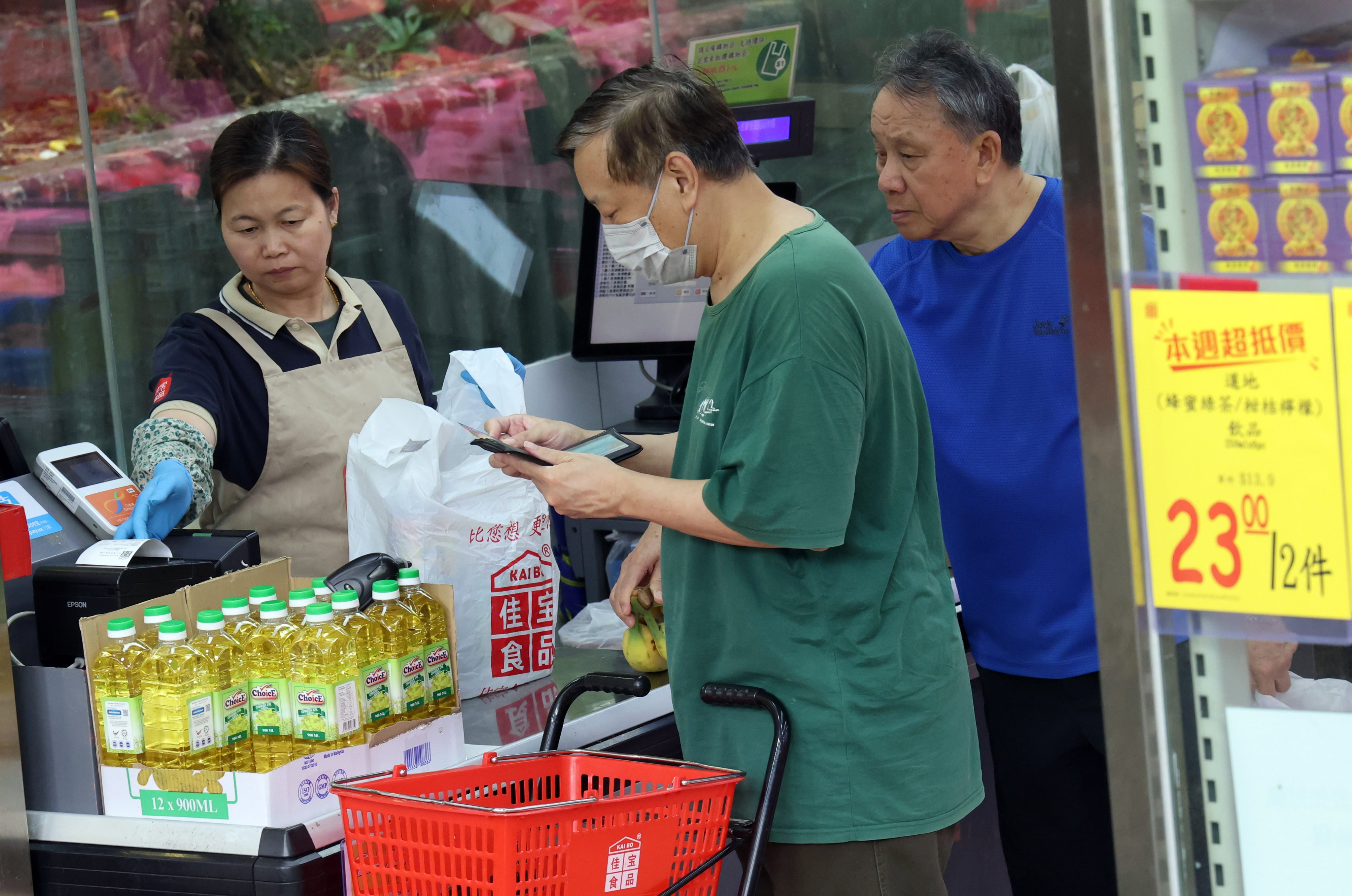 A cashier works in a supermarket in Lok Fu on April 29.  The government is adopting a new formula for calculating the minimum wage which takes into account the consumer price index. Photo: Jelly Tse