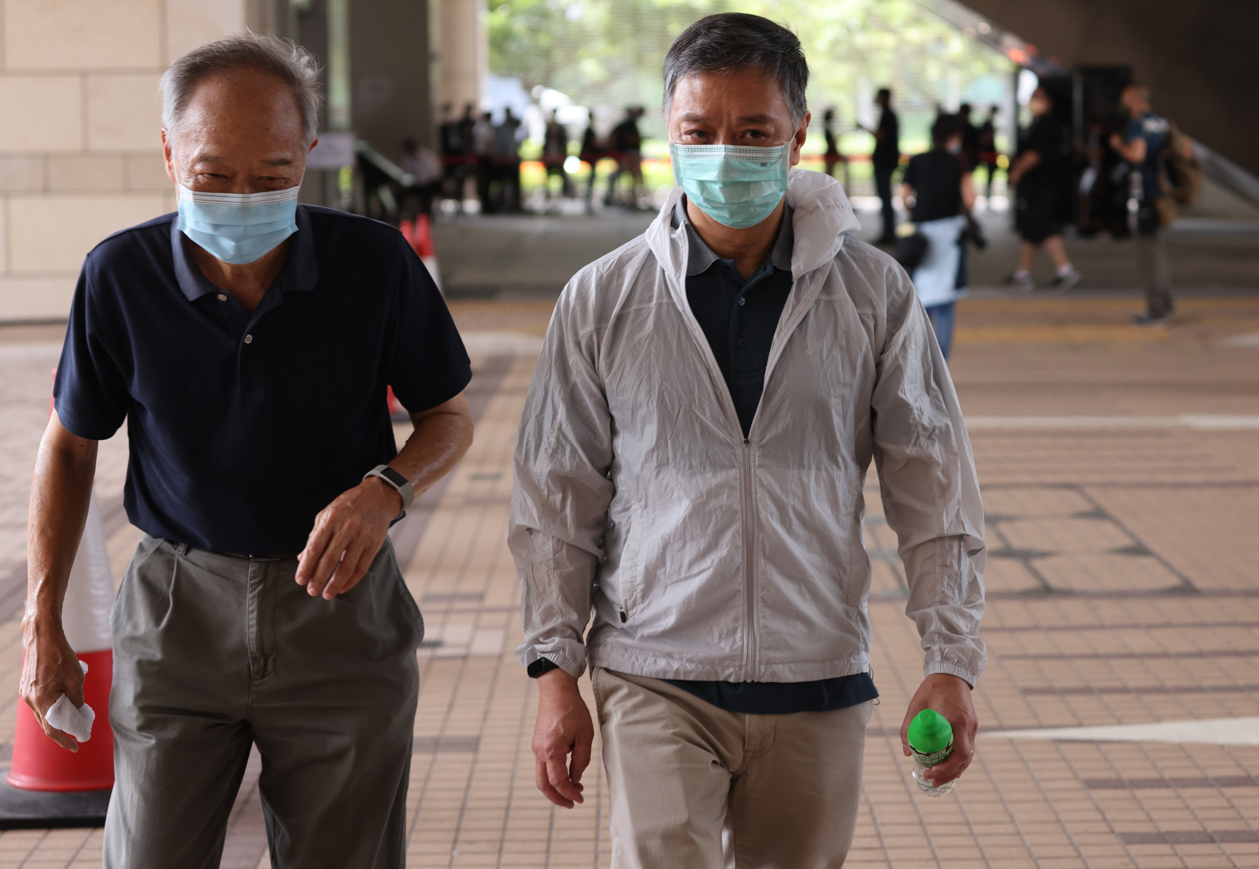 Apple Daily chief operating officer Chow Tat-kuen (white jacket) arrives at West Kowloon Magistrates’ Court at an earlier sitting. Photo: May Tse