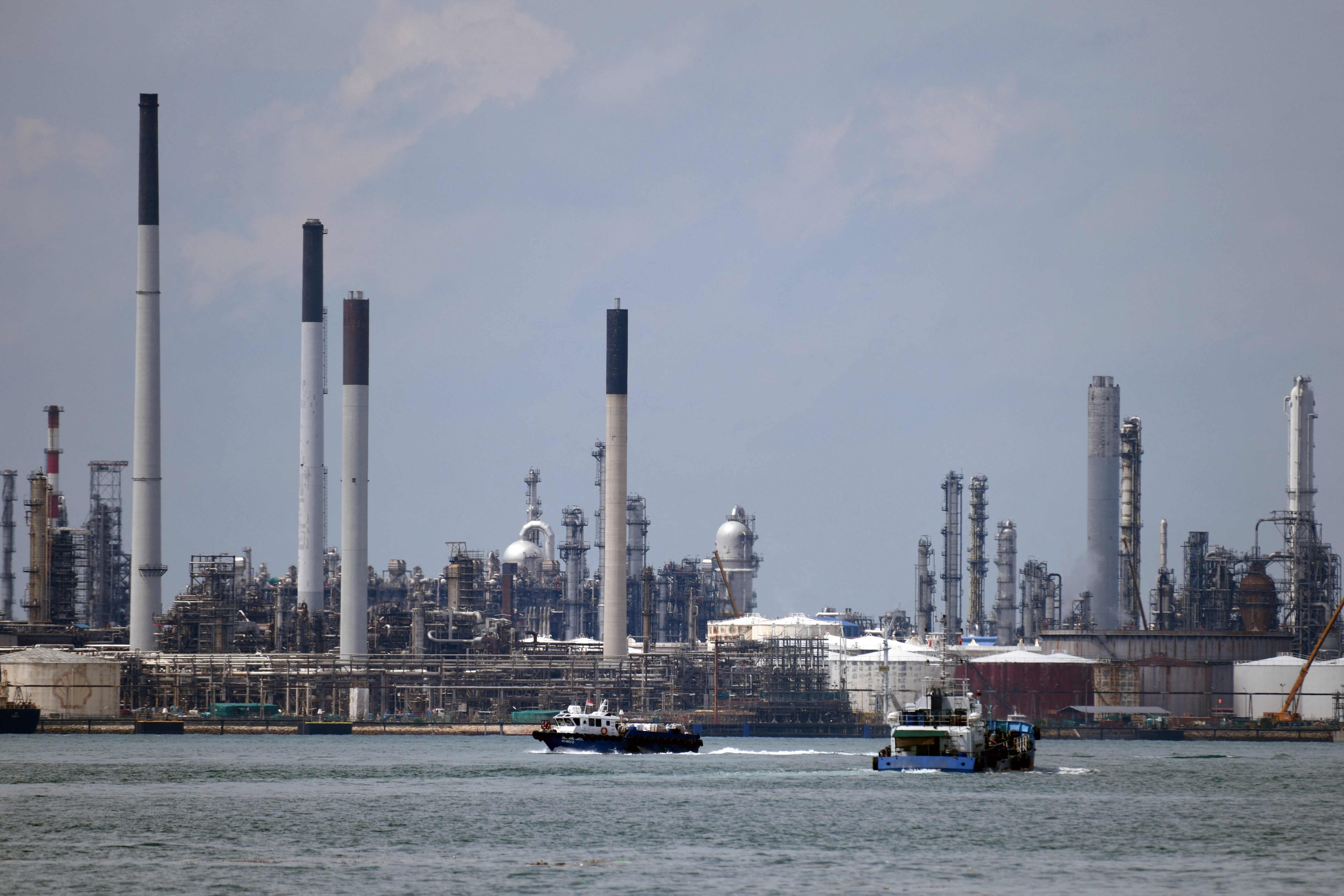 Boats sail past the Shell refinery on Pulau Bukom, or Bukom island, off Singapore. The facility opened in 1961. Photo: AFP