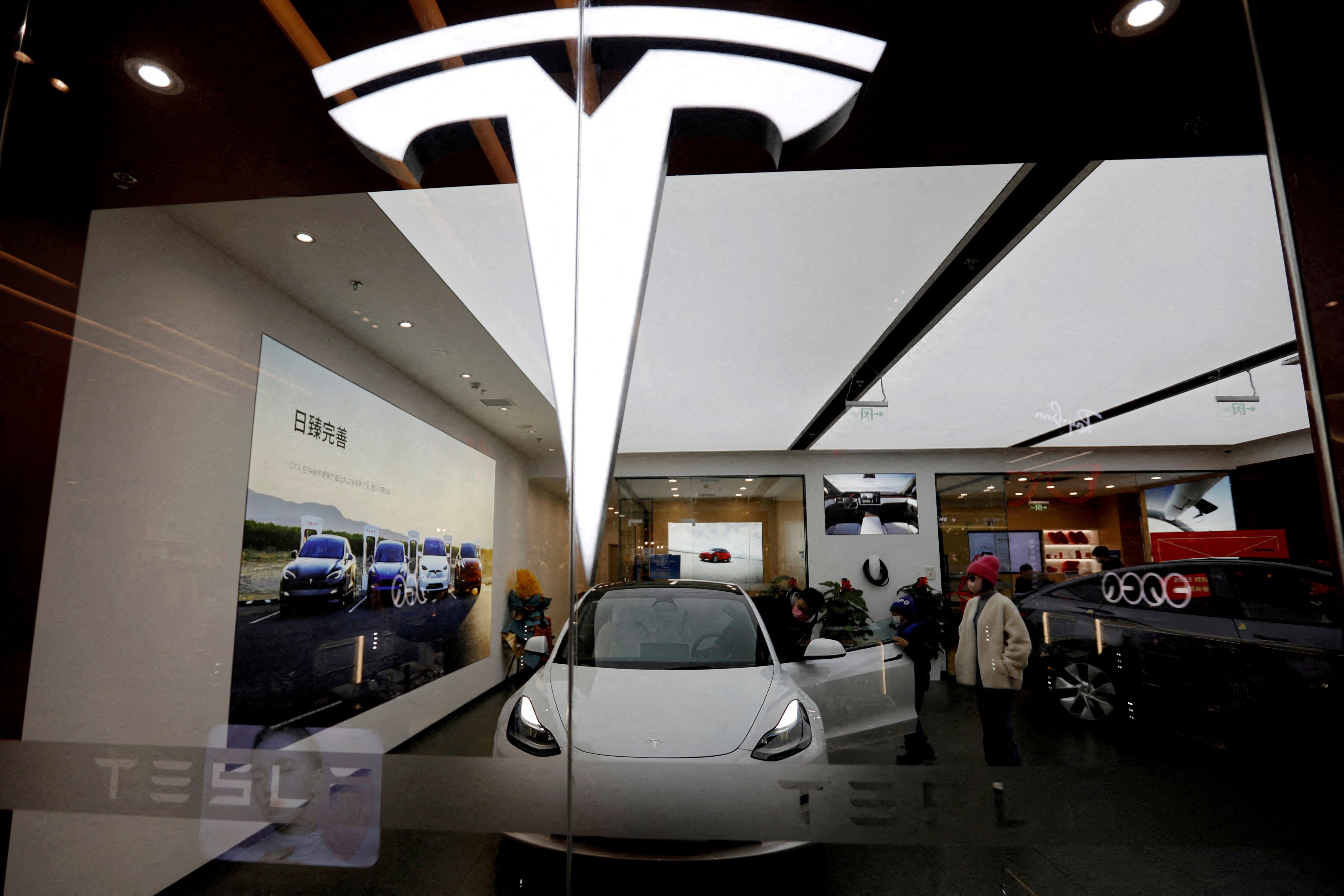 Visitors look at a Tesla Model 3 at a showroom of the US carmaker in Beijing on February 4, 2023. Photo: Reuters
