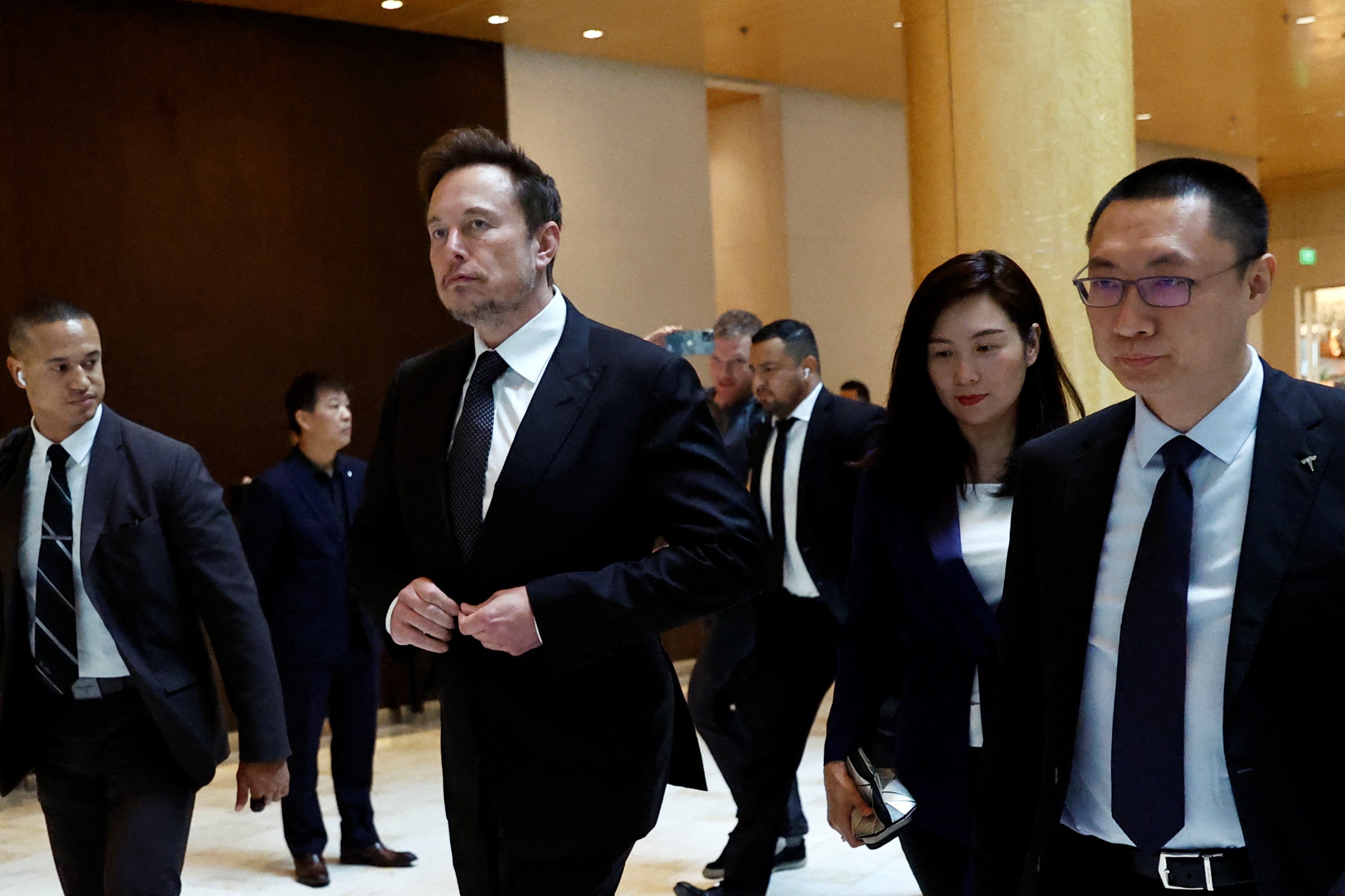 Tesla Chief Executive Officer Elon Musk (left) walks next to Tesla’s Senior Vice-President Tom Zhu (right) and Vice-President Grace Tao as he leaves a hotel in Beijing, China in May 2023. Photo: Reuters