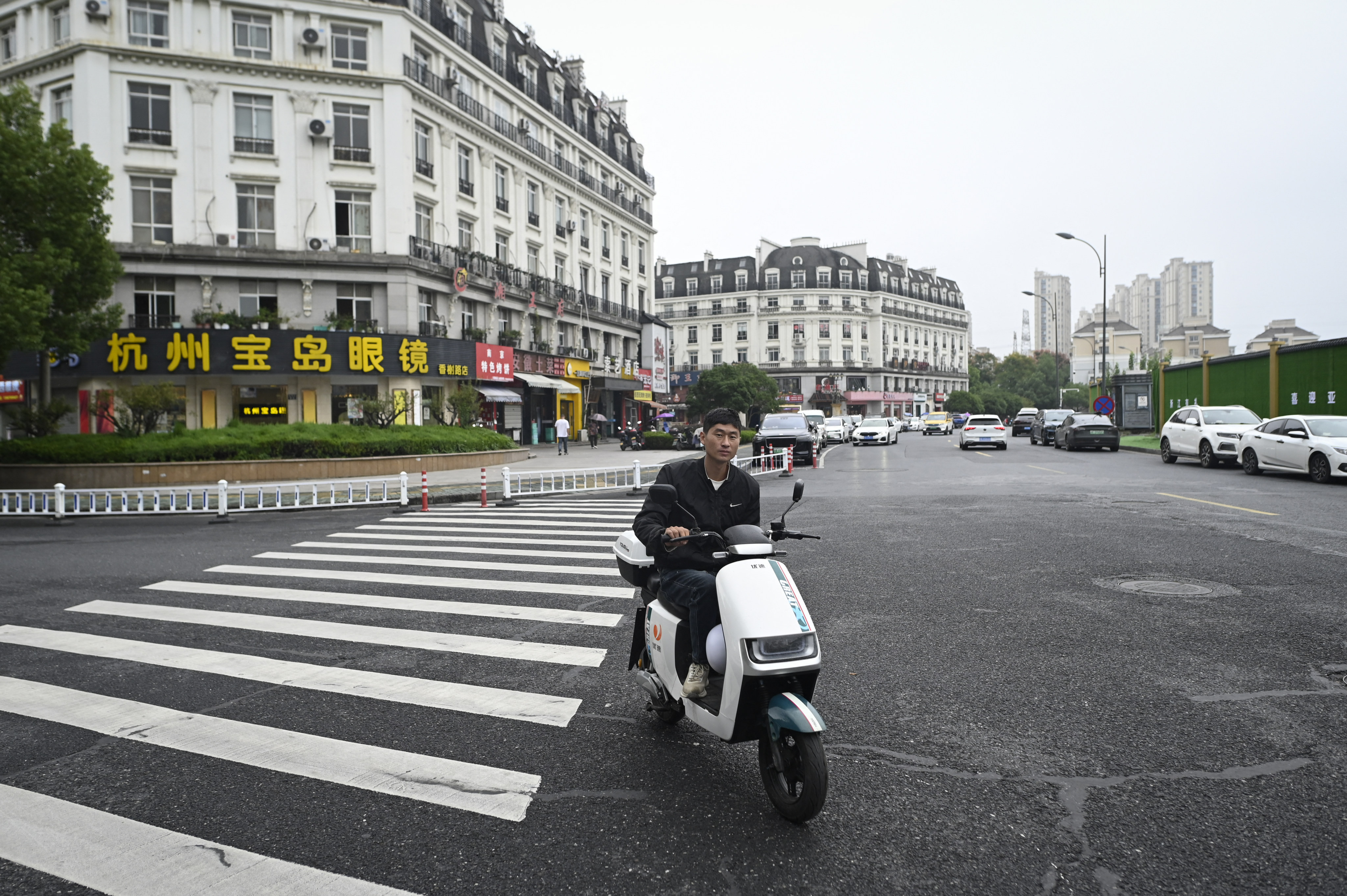 A man riding his electric bicycle on a street near a residential area modelled on Paris in Hangzhou. Photo; AFP