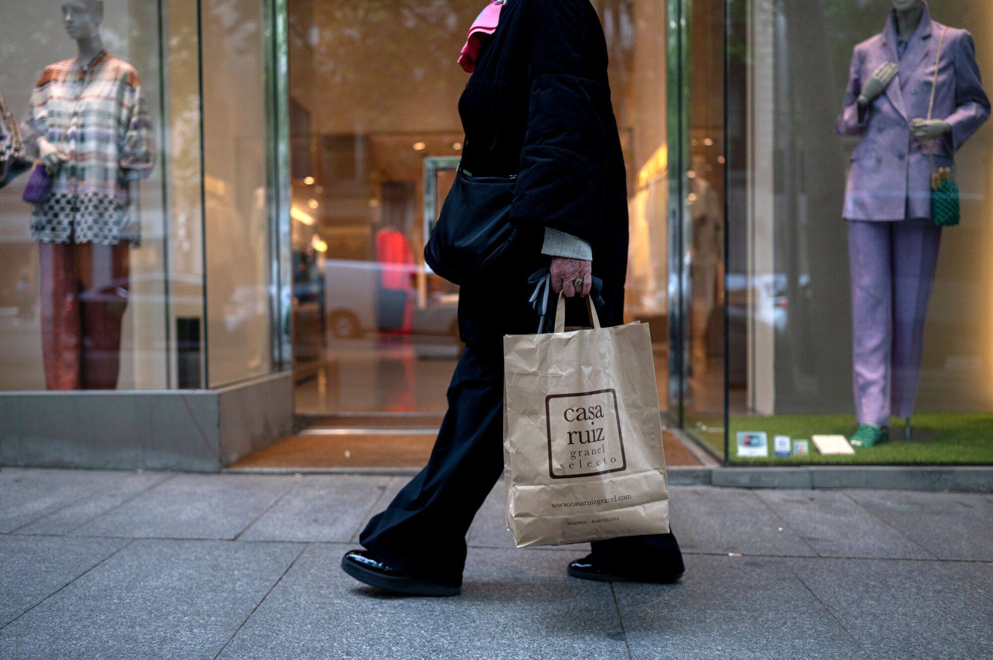 A shopper carries a bag in central Madrid. Since the UK scrapped a tax rebate scheme for tourists, many travellers have instead visited the Spanish capital to take advantage of tax breaks. Photo: Bloomberg