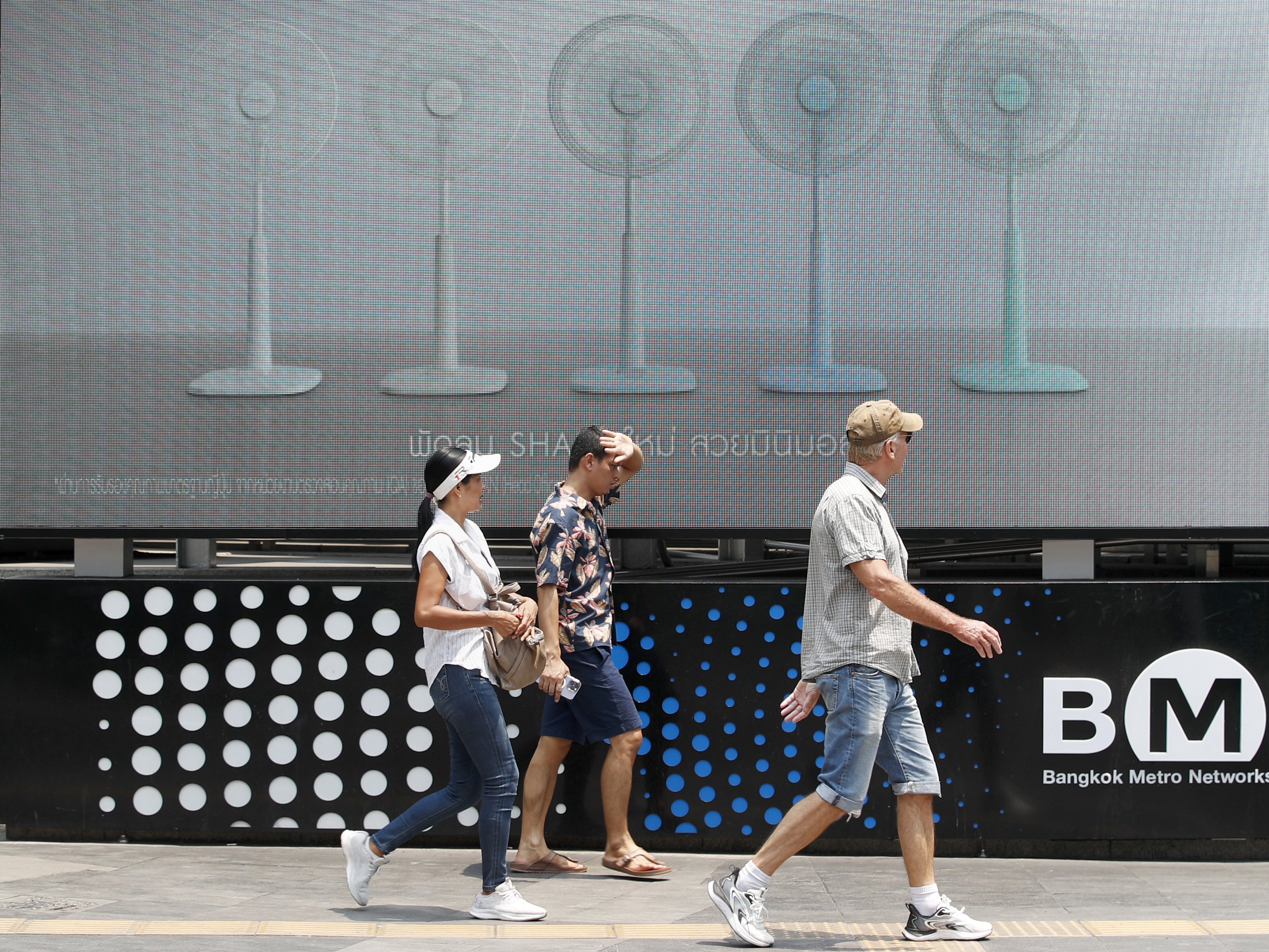 Pedestrians walk past an electric fan advertisement during hot weather in Bangkok, Thailand, 01 May 2024. Thailand is facing a severe heatwave, with temperatures soaring to record highs of over 44 degrees Celsius in some areas. Photo: EPA-EFE