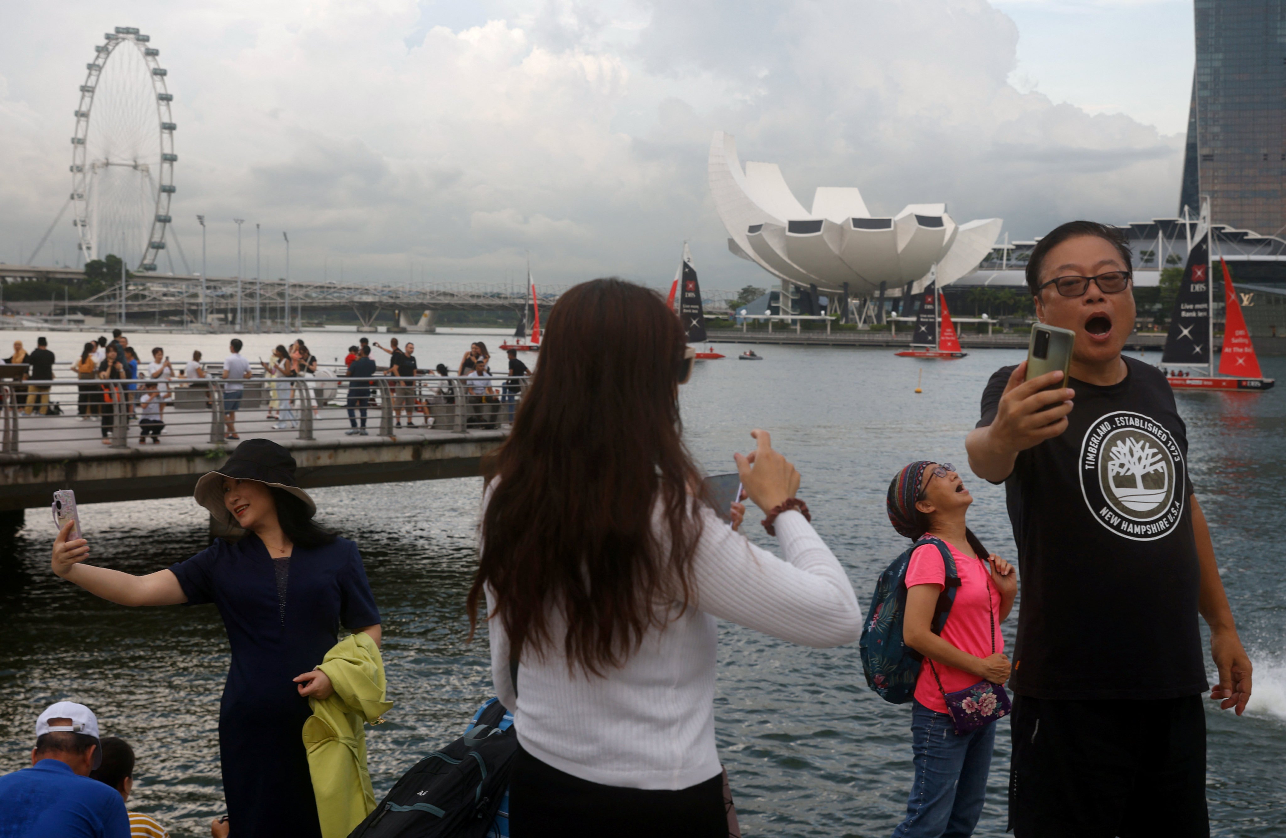 Chinese tourists take selfies at Marina Bay in Singapore. Photo: Reuters