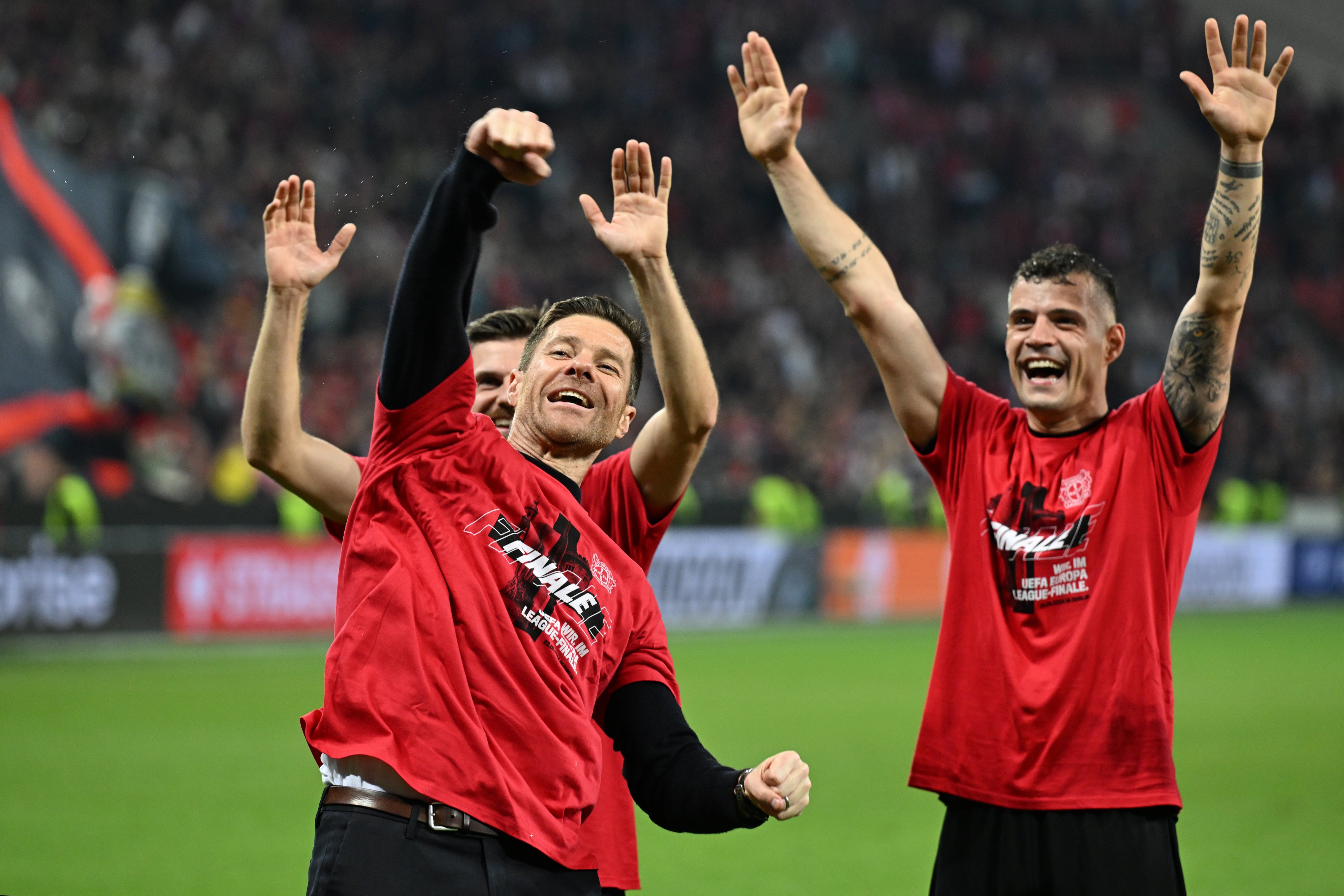 Leverkusen coach Xabi Alonso, Jonas Hofmann (behind Alonso) and Granit Xhaka celebrate with fans after winning their Europa League semi-final. Photo: dpa
