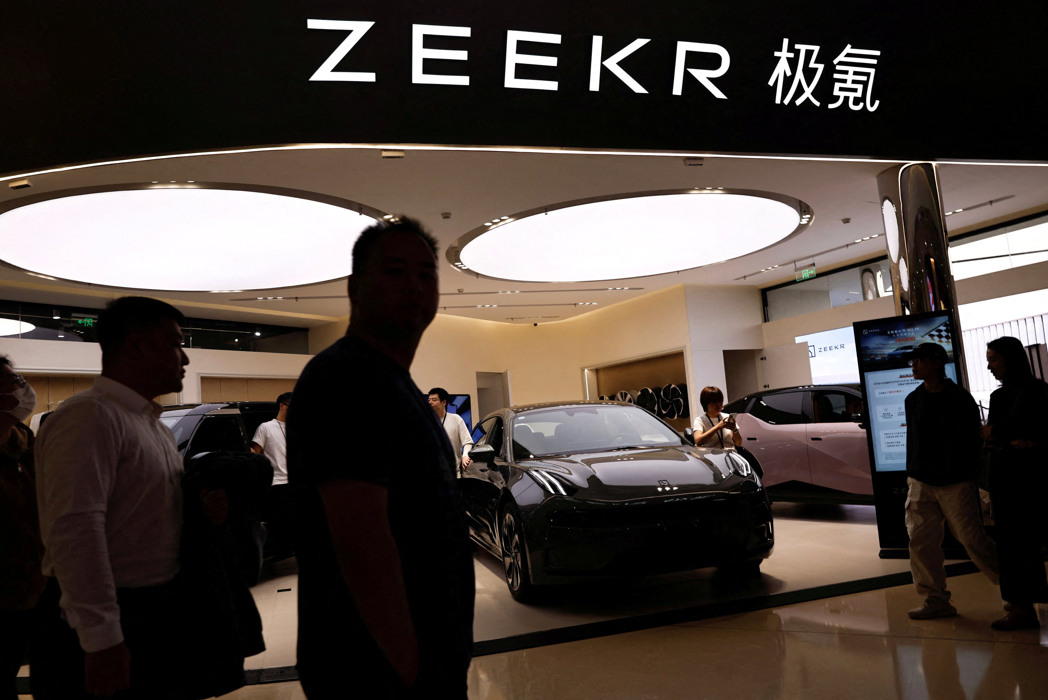 People walk past a booth of Zeekr, Chinese automaker Geely’s premium EV brand, at a shopping mall in Beijing in November 2023. Photo: Reuters