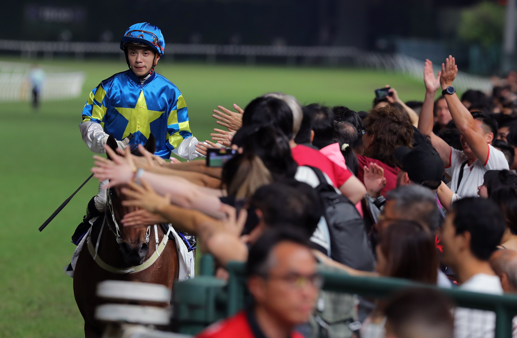 Angus Chung high-fives the Happy Valley crowd.