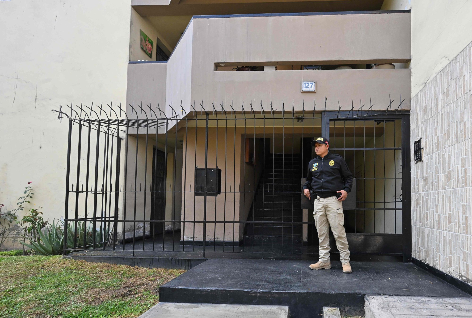A police officer stands guard as a search is conducted at the home of Nicanor Boluarte, brother of Peruvian President Dina Boluarte, in Lima on Friday. Photo: AFP