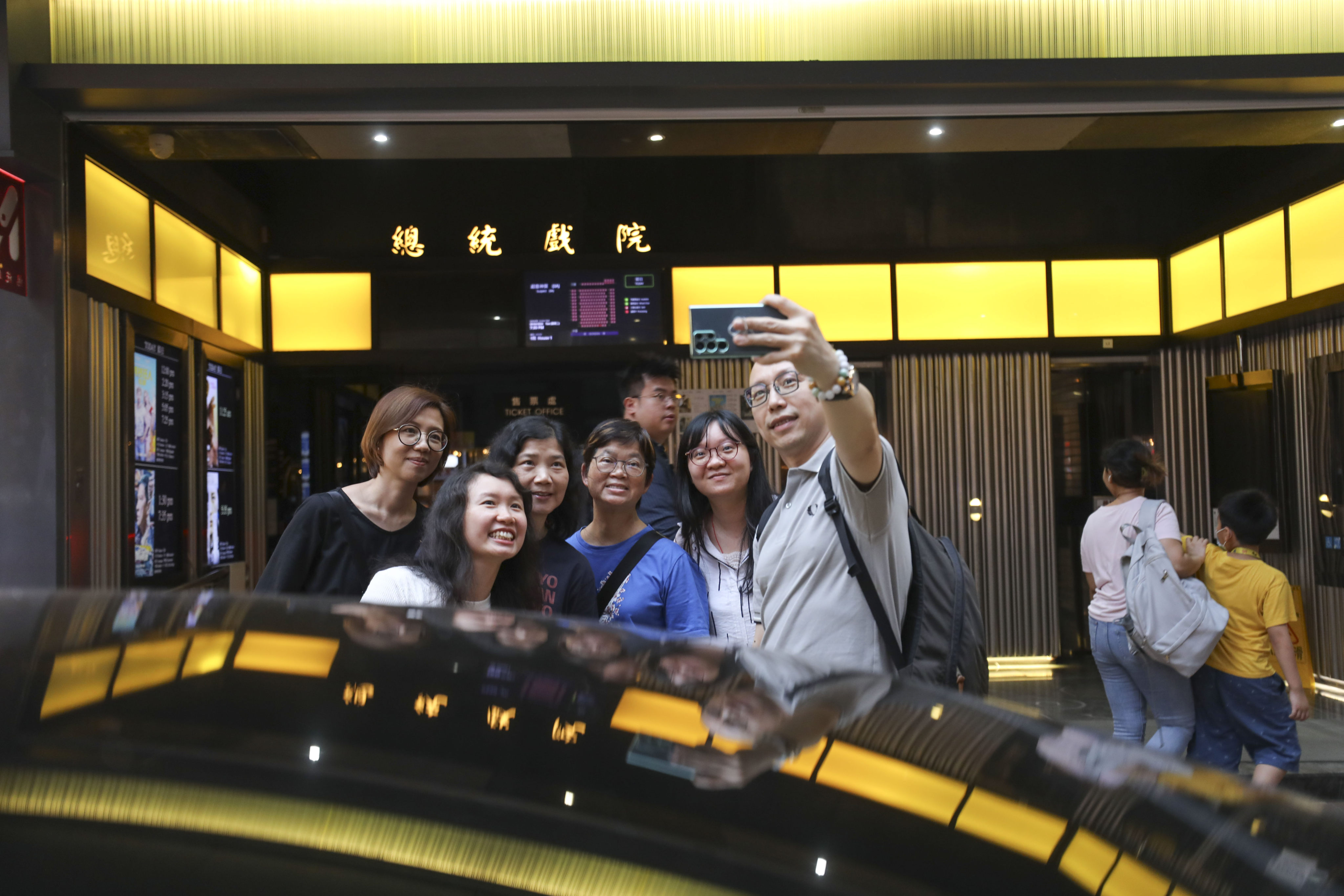 People pose for pictures at the President Theatre in Causeway Bay after all tickets were sold out on its last day of business on April 30, 2024 after nearly 60 years of operation. Photo: SCMP / Xiaomei Chen