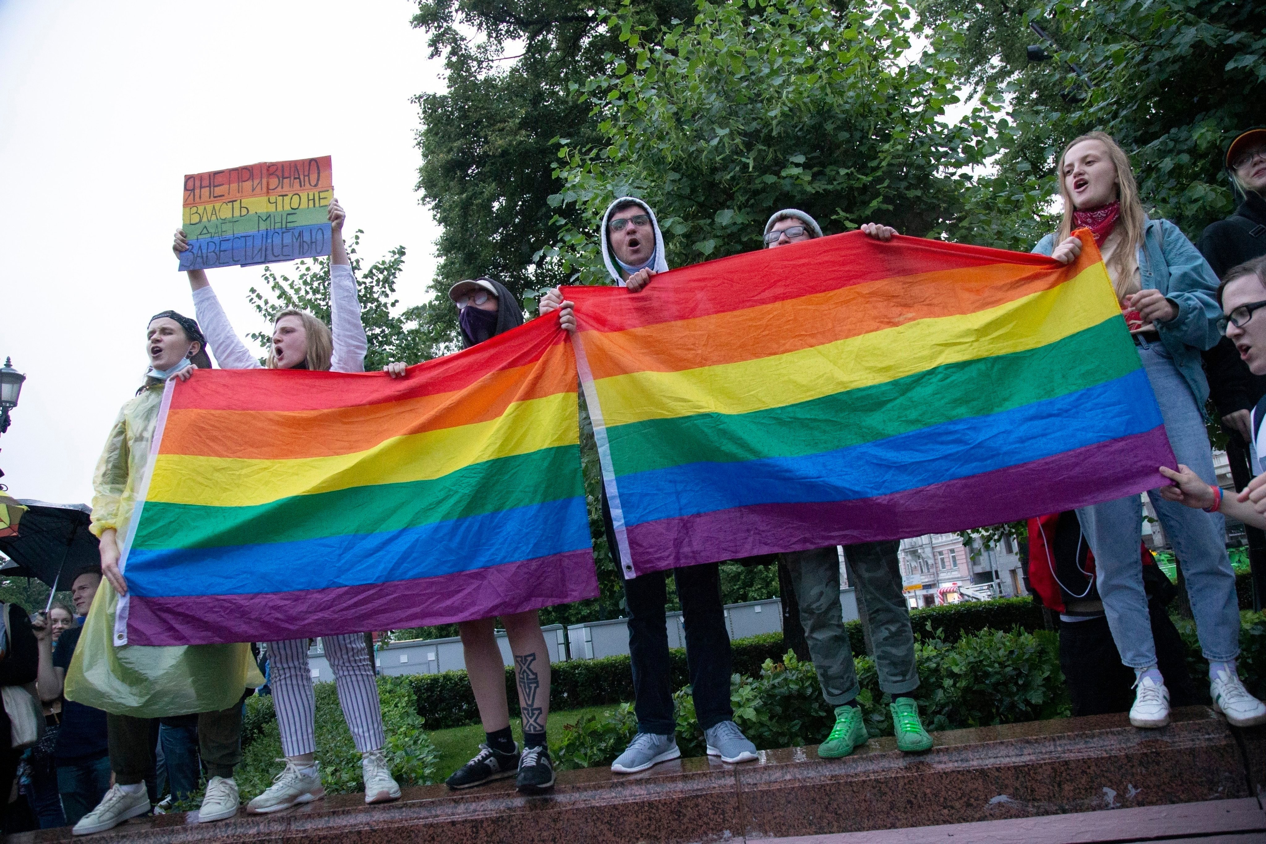 LGBTQ activists wave flags during a rally in Moscow. Russia does not ban homosexuality itself but because it cannot be discussed, it is a social taboo. Photo: AP