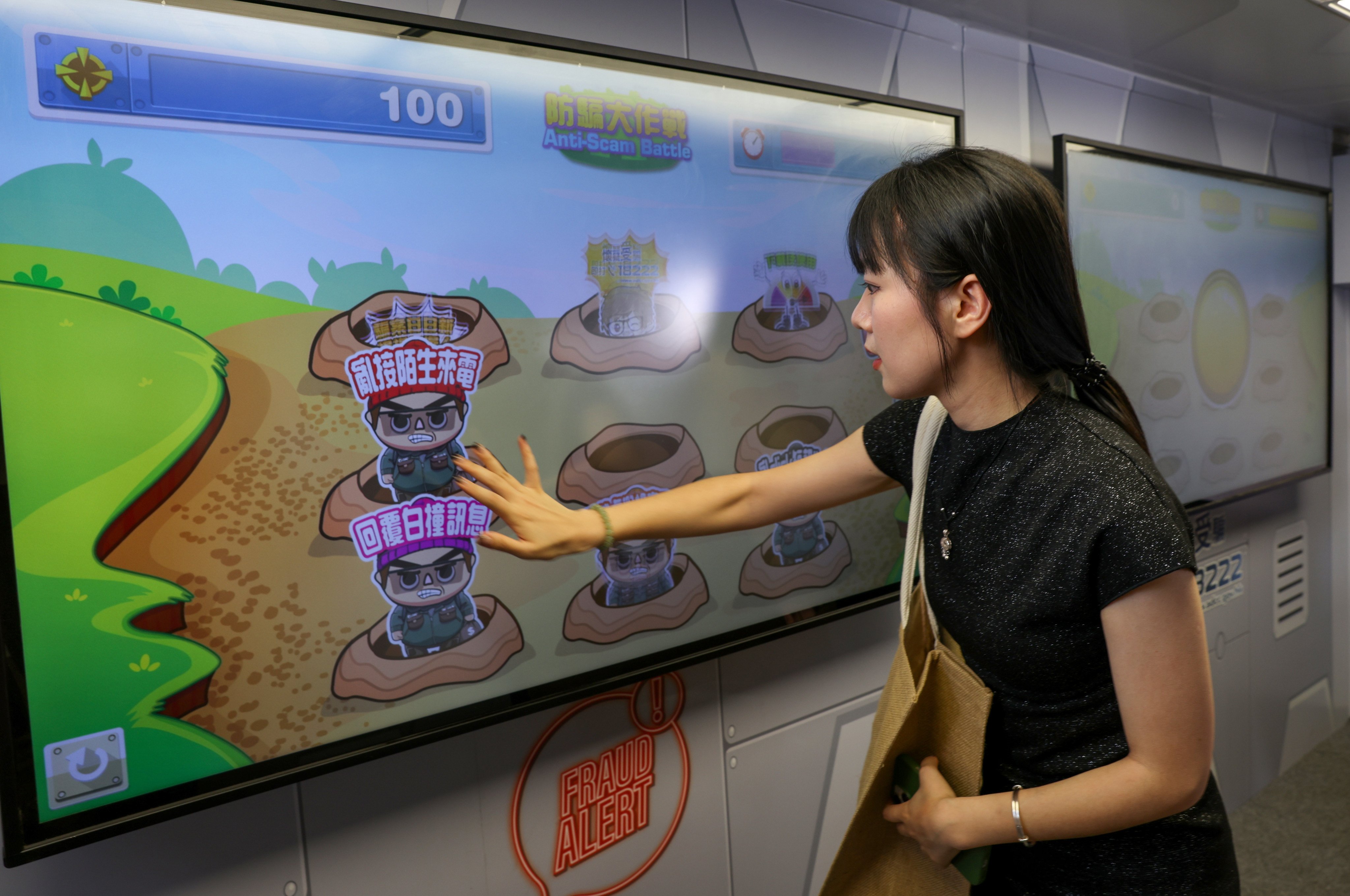 A tourist from mainland China plays an anti-scam game at a police publicity vehicle. Photo: Yik Yeung-man