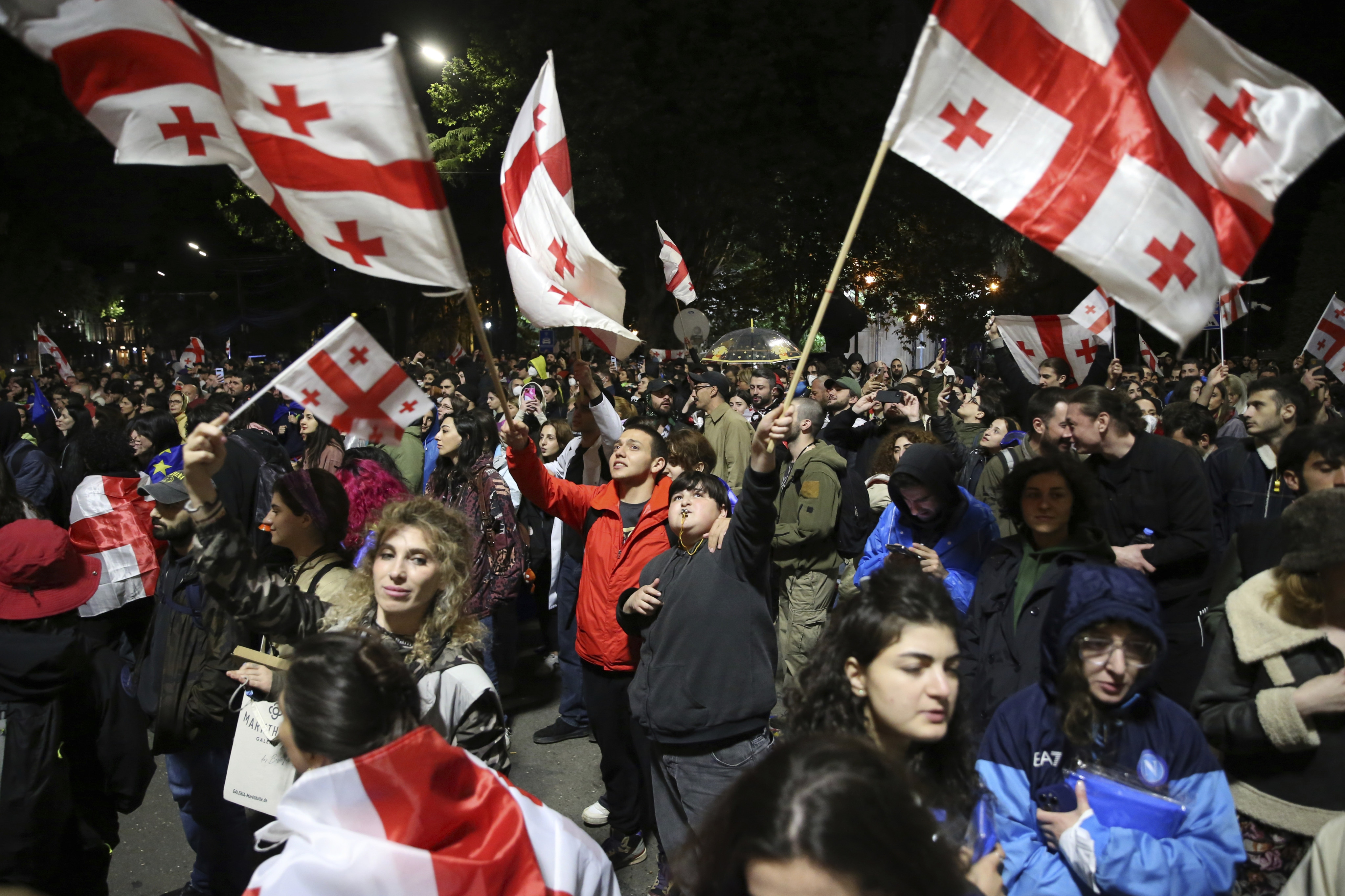 Demonstrators waving Georgian national flags gather in front of the parliament building early Monday. Photo: AP