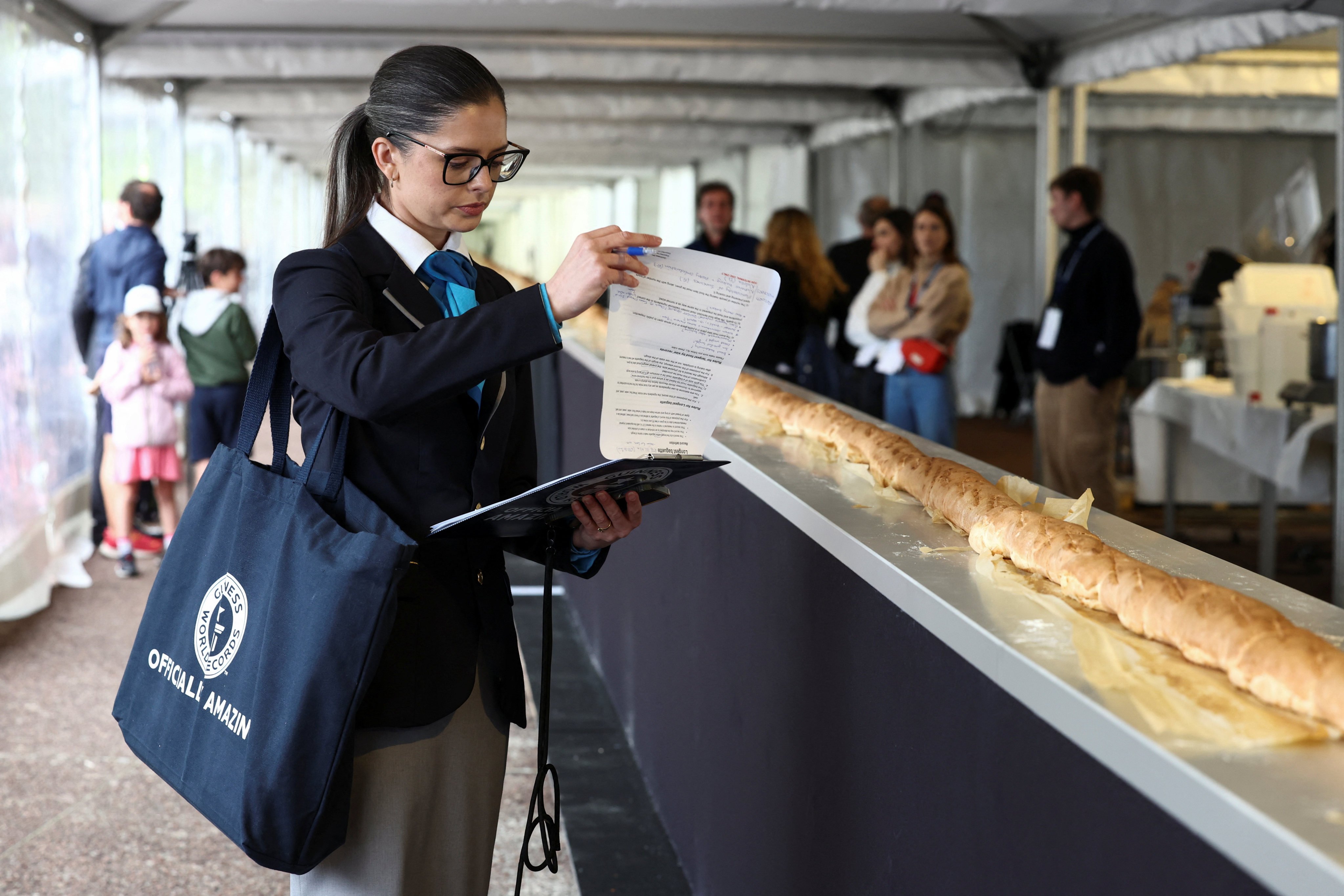 Joanne Brent, adjudicator of the Guinness World Records, stands near the baguette during her inspection of an attempt to beat the world record for the longest baguette. Photo: Reuters