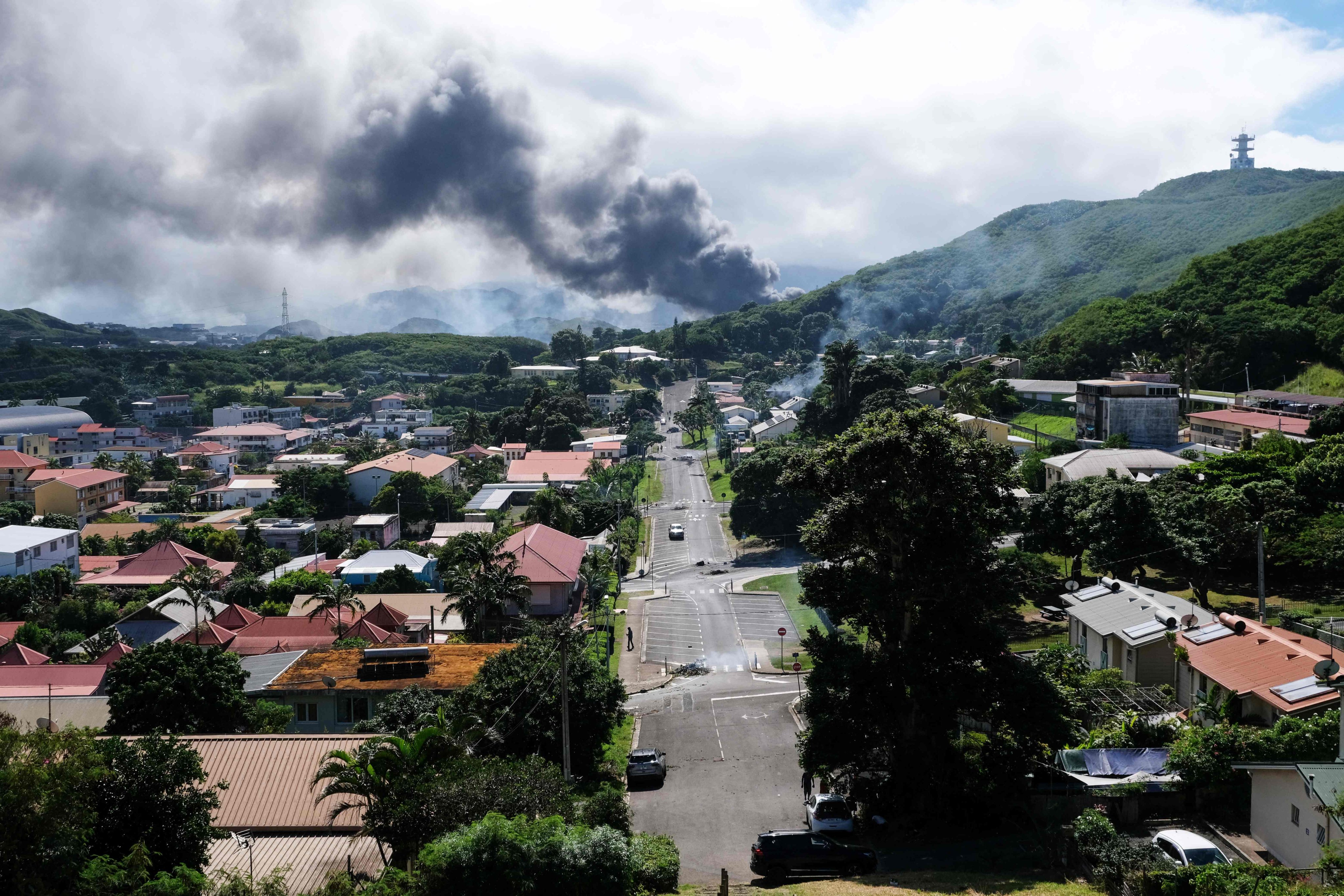 Smoke rises in the distance on Tuesday amid unrest in Noumea, New Caledonia, over a constitutional bill aimed at enlarging the electorate in the French overseas territory. Photo: AFP