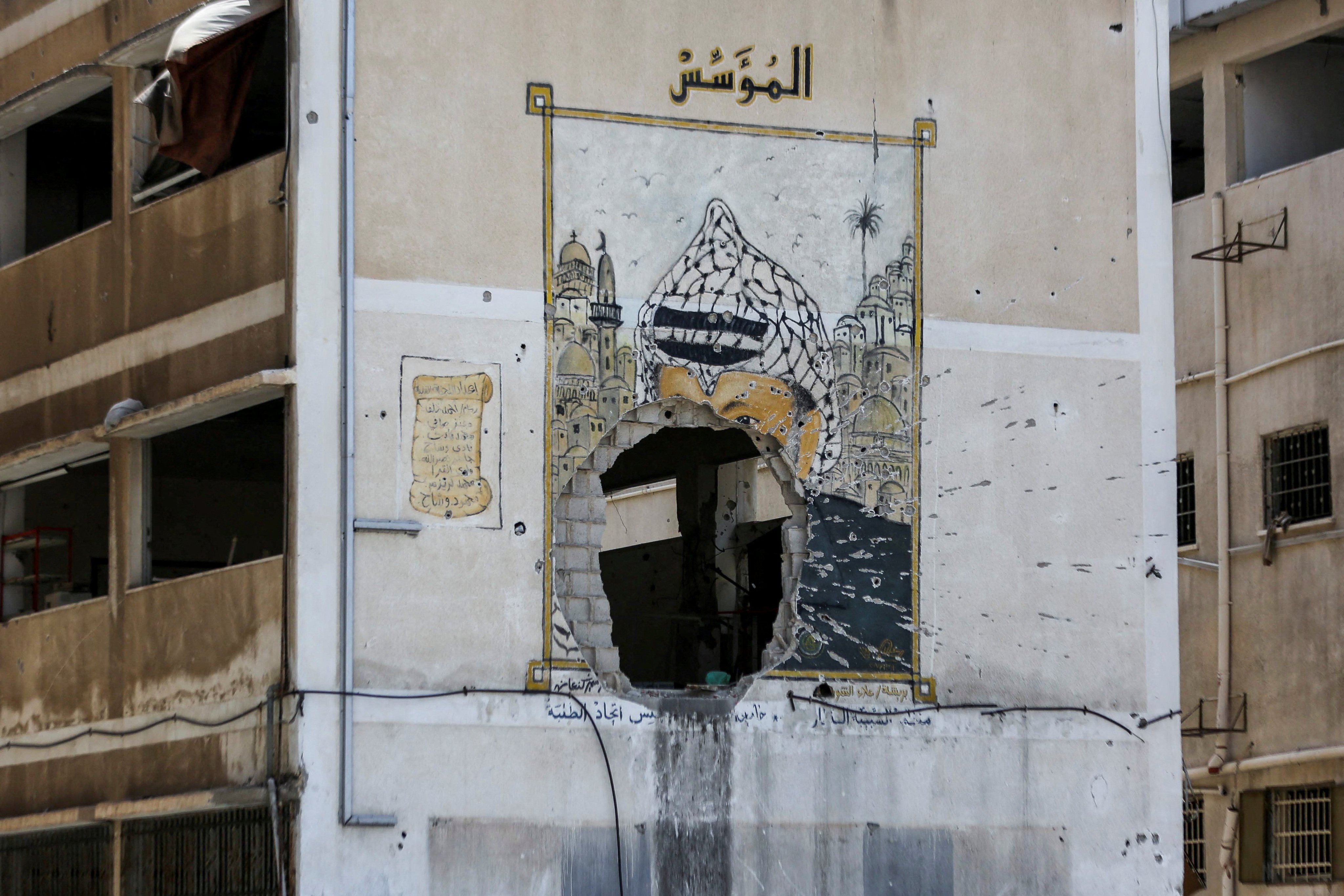 A damaged building with a mural depicting Yasser Arafat at a university in Gaza City. Photo: Reuters