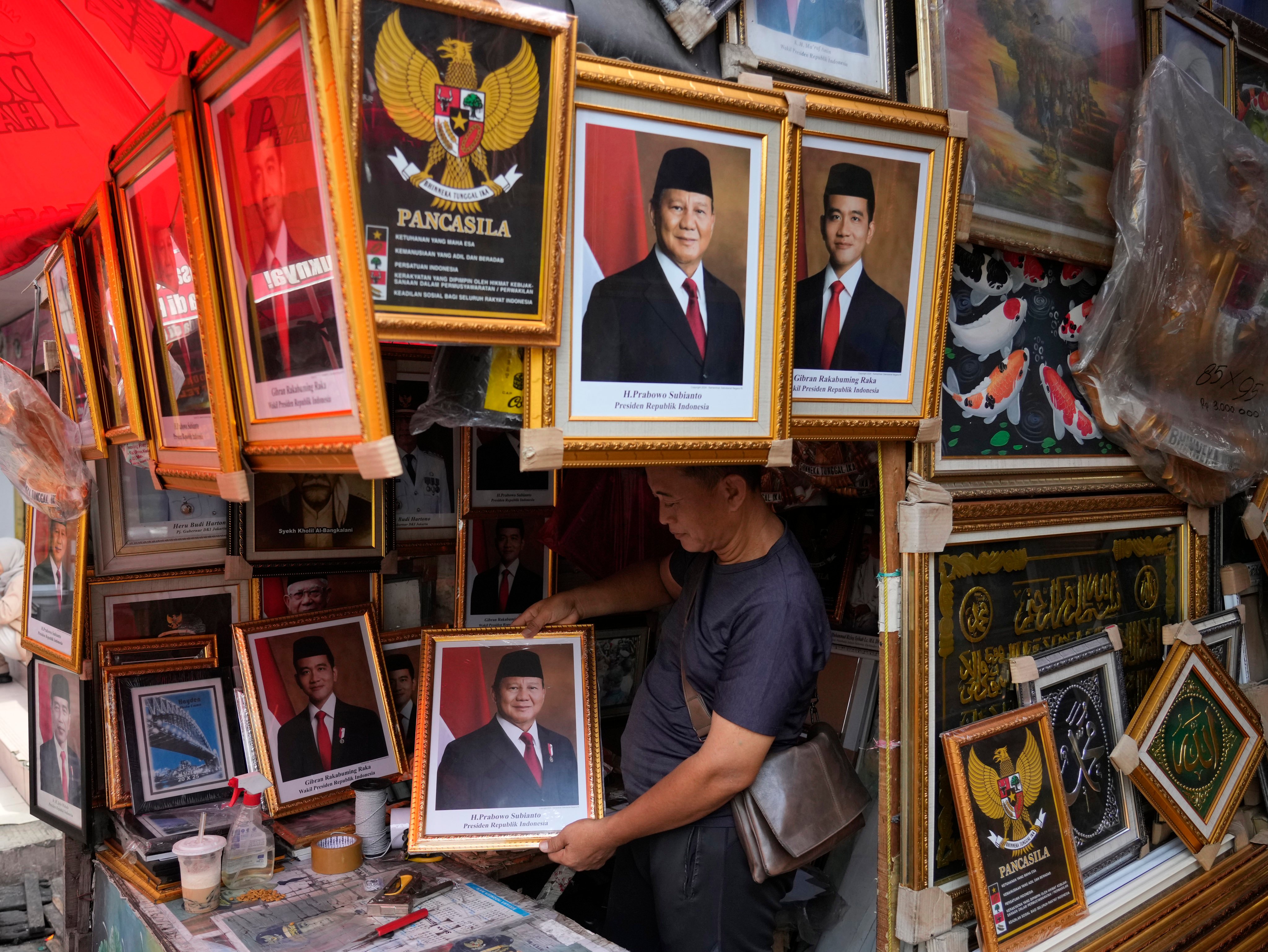 A vendor holds a portrait of Indonesian president elect Prabowo Subianto at a market in Jakarta. Prabowo, 74, is set to take over the presidency from Joko Widodo on October 20. Photo: AP
